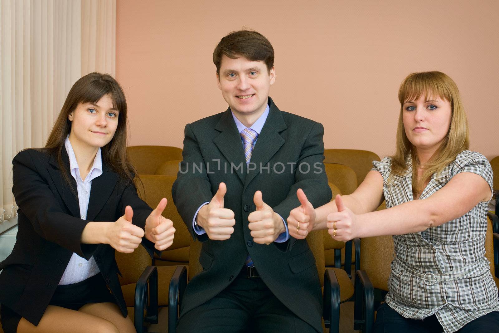 Team of cheerful businessmen show thumb up