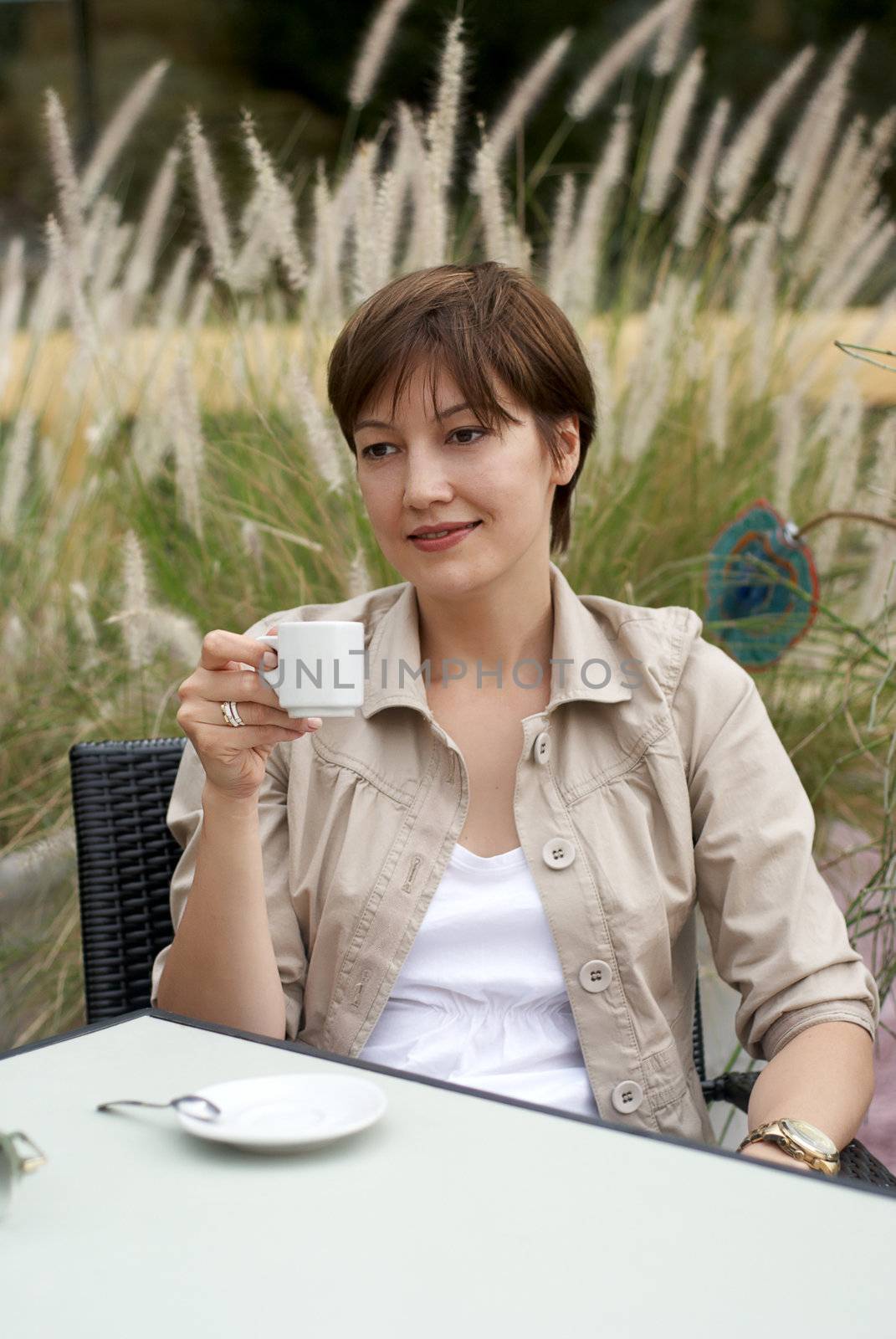 The woman having a rest in cafe with a coffee cup