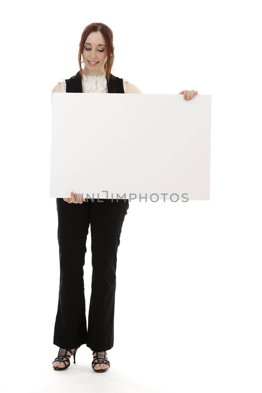Young business woman wearing a business suit with a happy expression looking down on a white board against white background