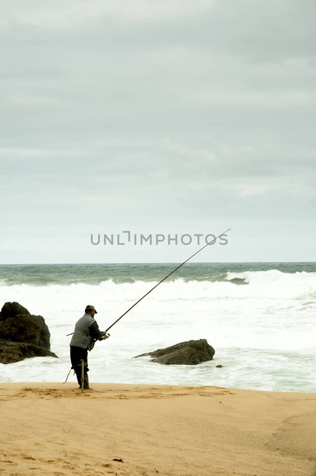 Man fising nearby stormy beach