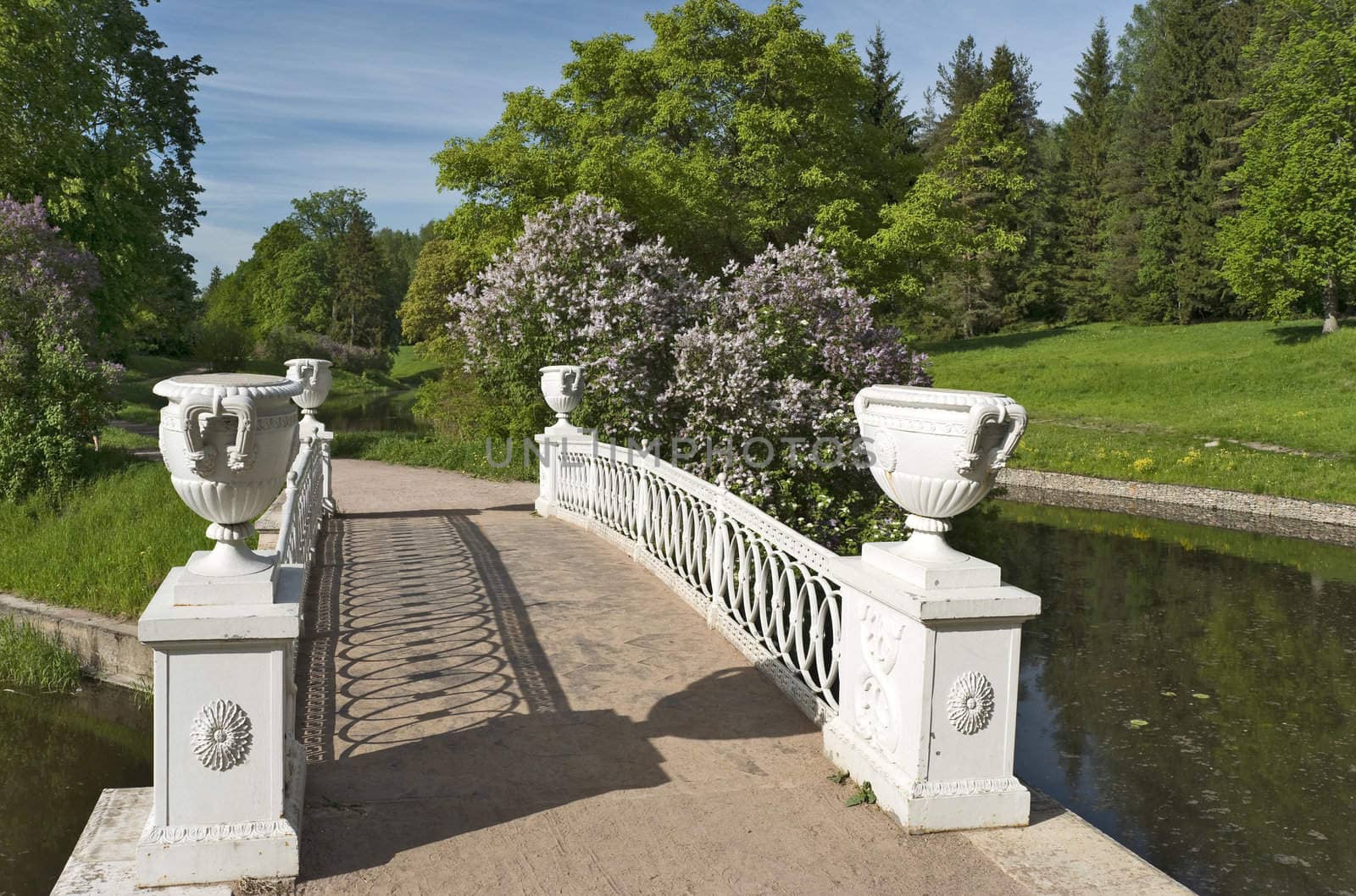 Ancient bridge with vases and blossoming lilac in the park close up