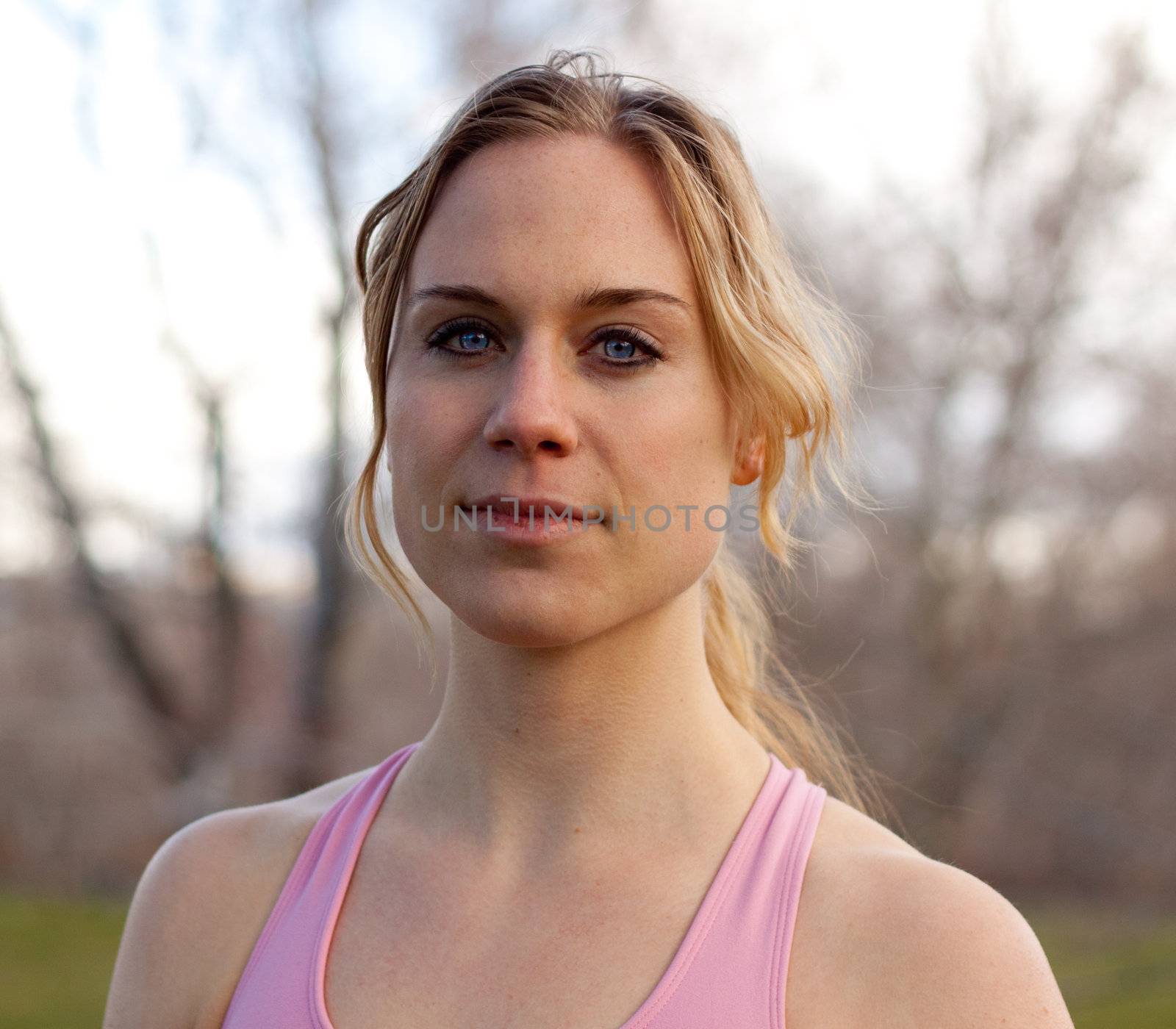 A stunning young lady is getting ready to exercise in the park.