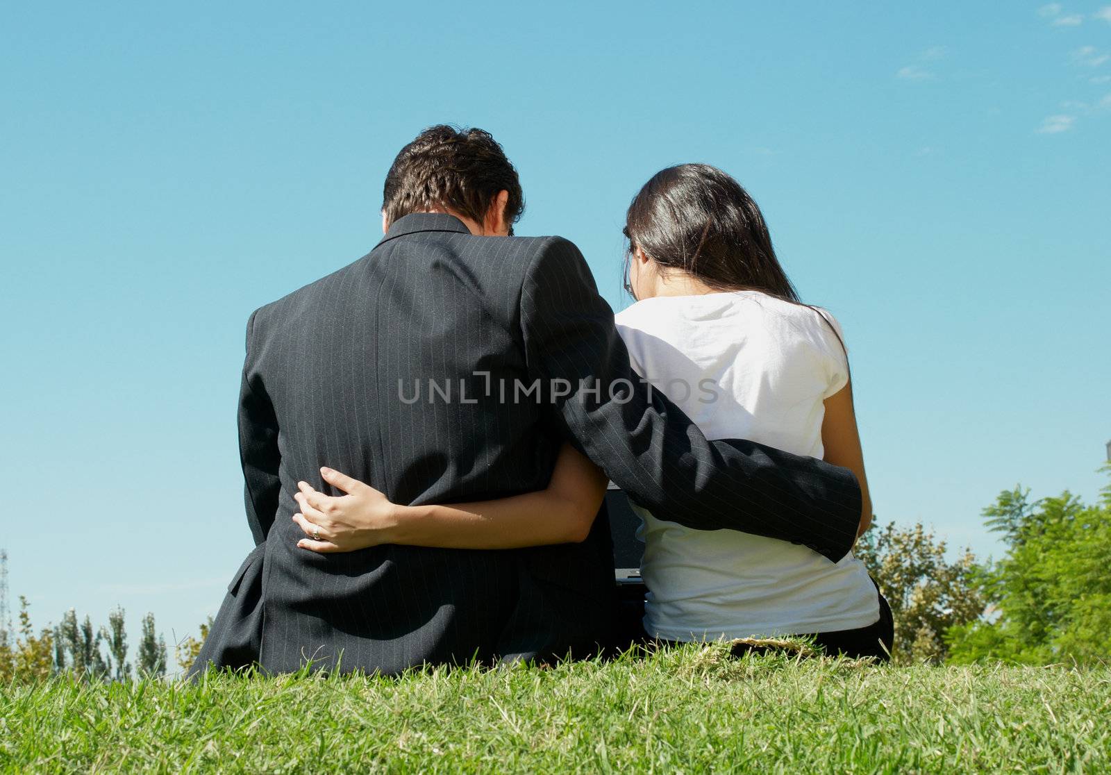 Young pair in park with the laptop