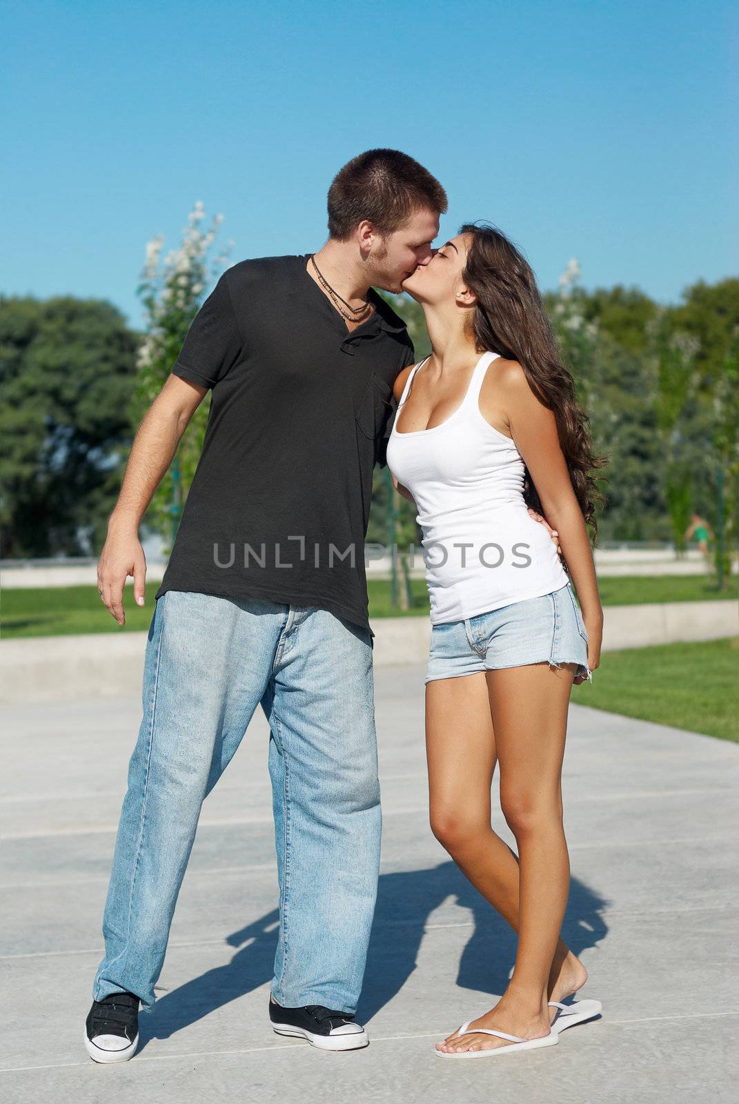 Happy young pair kissing outdoors