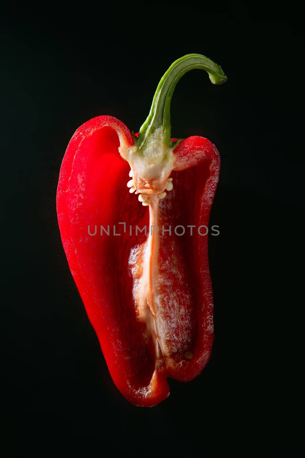 Half cutted red pepper isolated over black background
