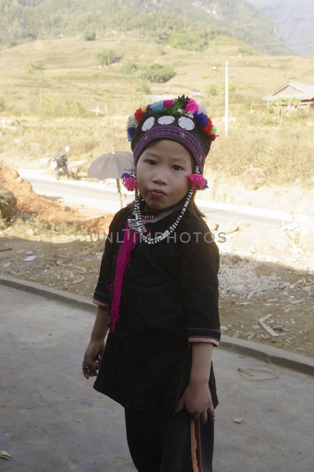 Black is also the color of clothing for children. This little boyl is wearing a cap embroidered with multicolored wool tassels.