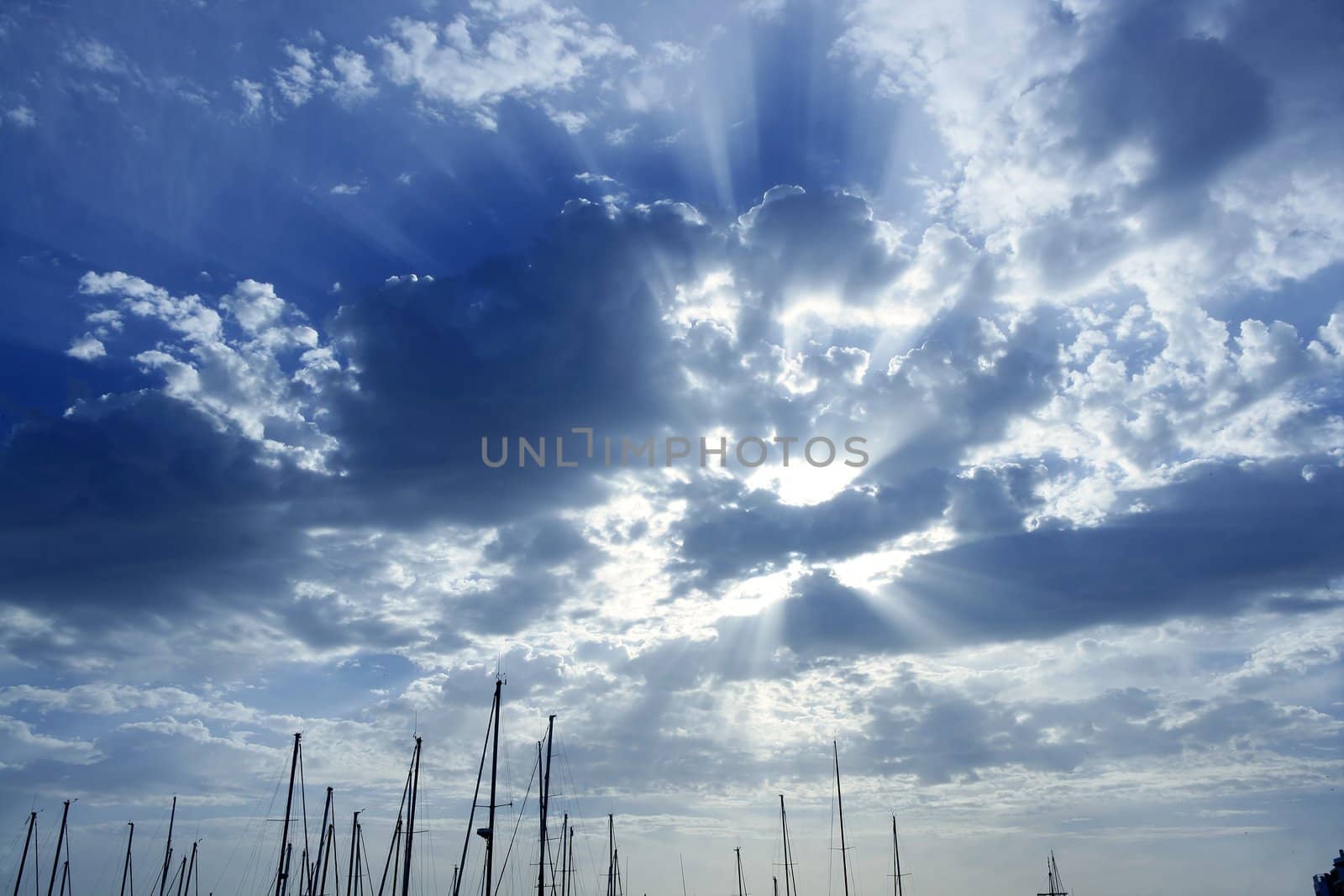 Cloudy sunset sky with sailboat mast by lunamarina