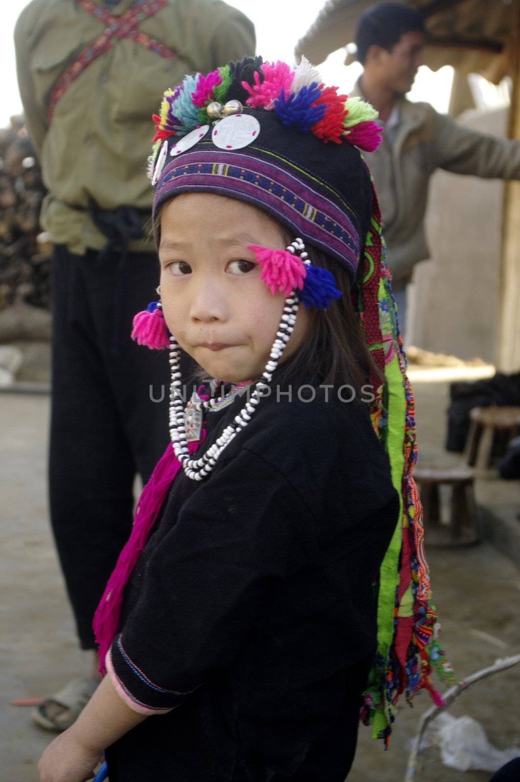 Black is also the color of clothing for children. This little girl is wearing a cap embroidered with multicolored wool tassels.