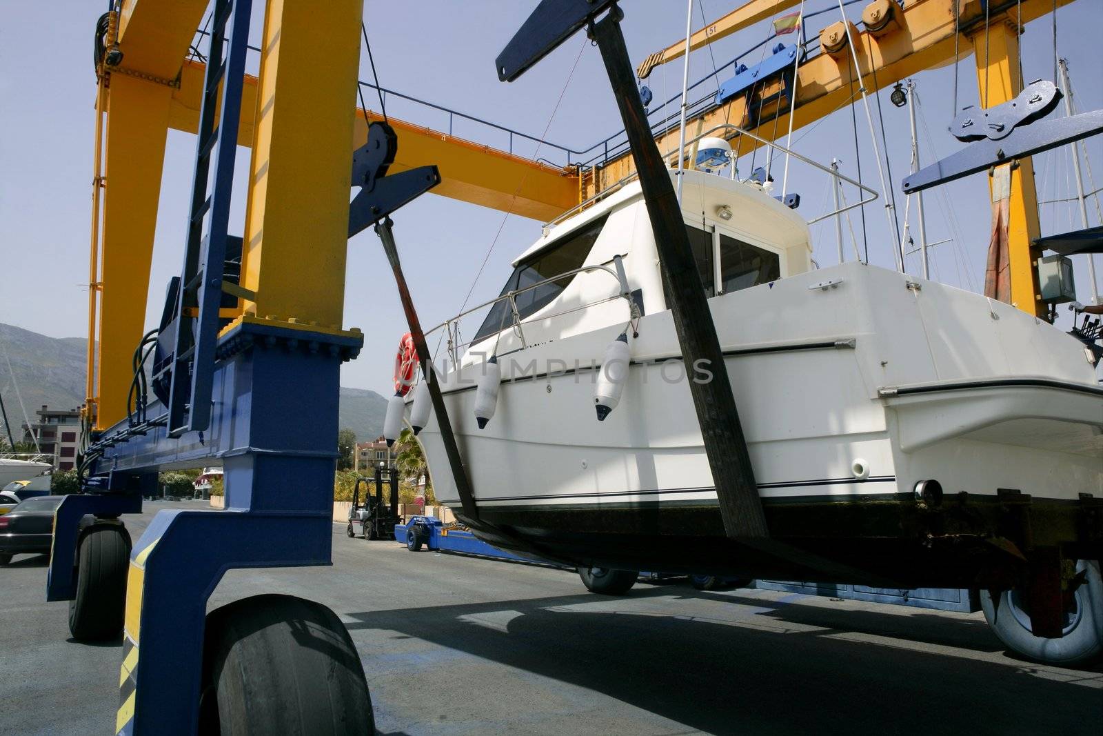Dock crane elevating a fishing boat in Mediterranean marina