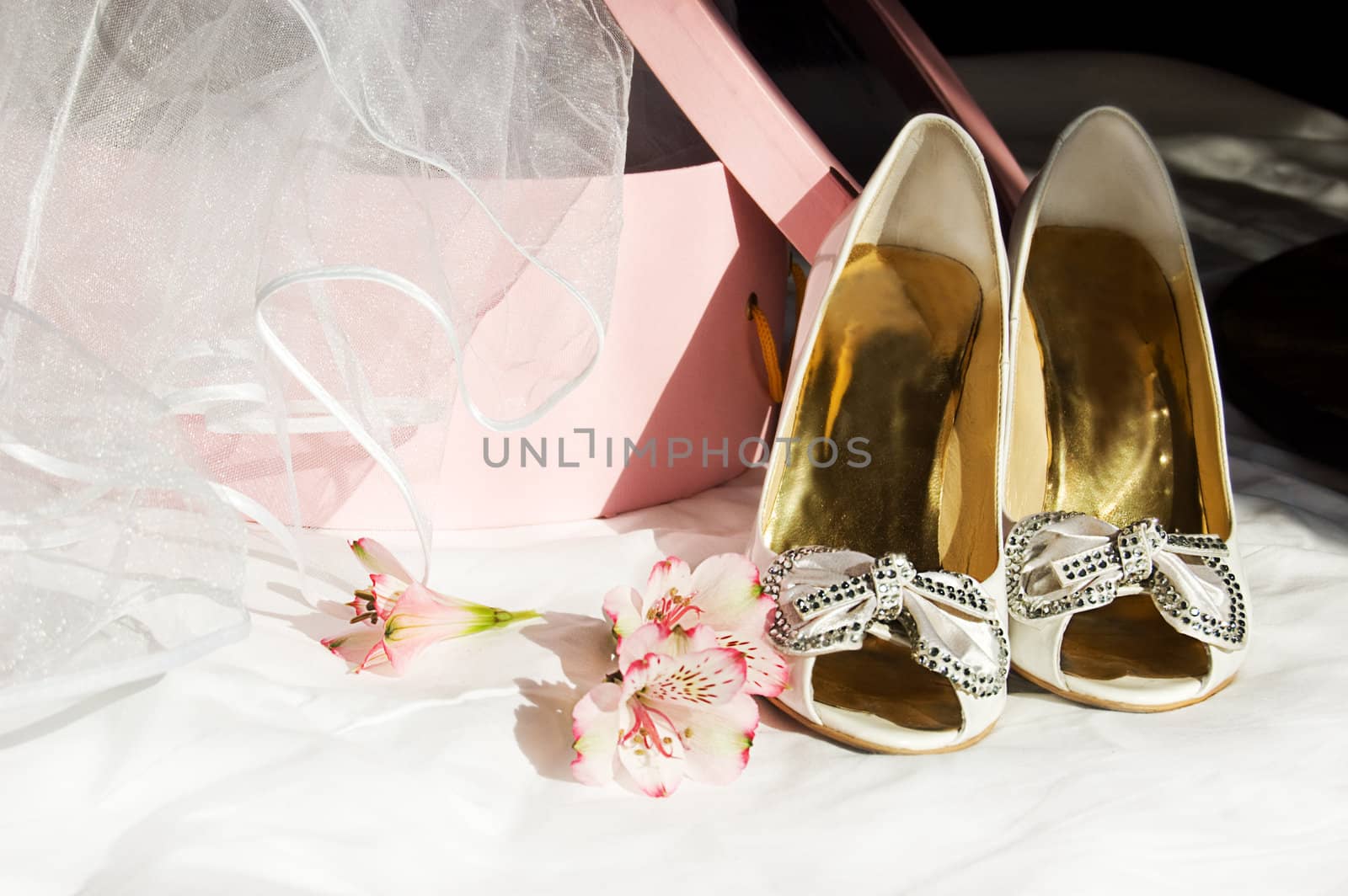 Wedding shoes, veil and box over dark background