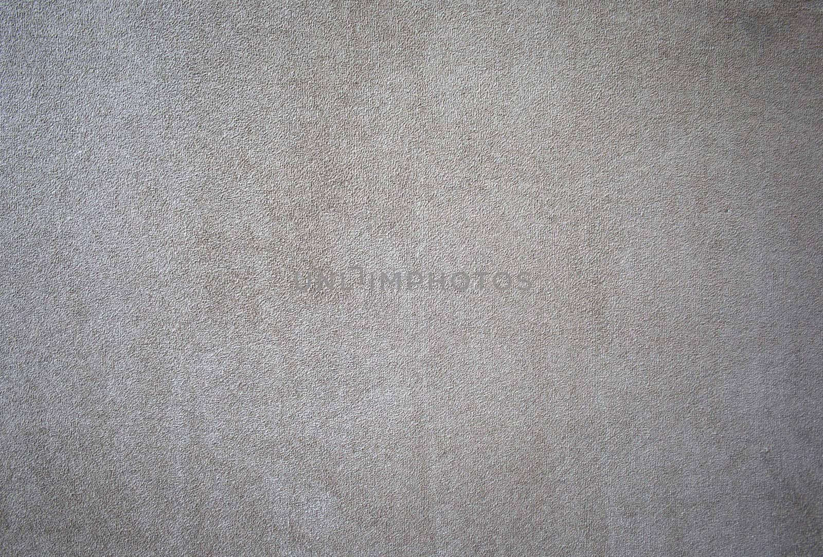 A background or texture of a beige colored suede swatch