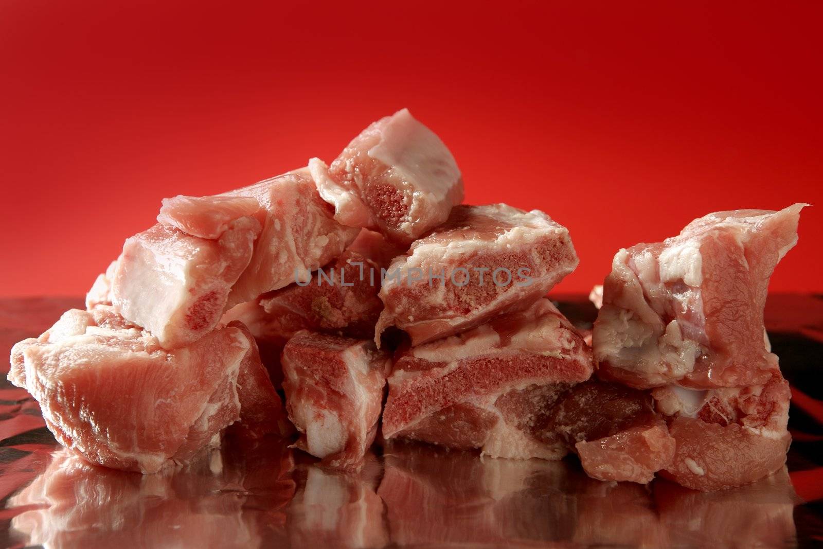 Pig, pork raw meat pieces over red background