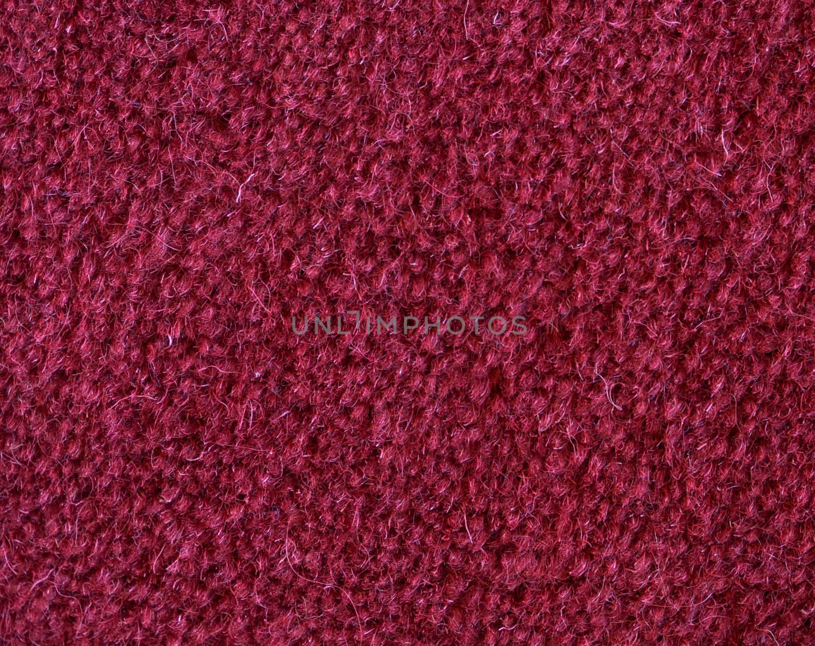 Macro of a red carpet woven from wool.