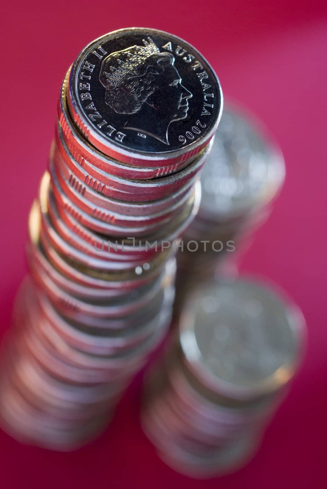 a large stack of australian dollar coins on a red background