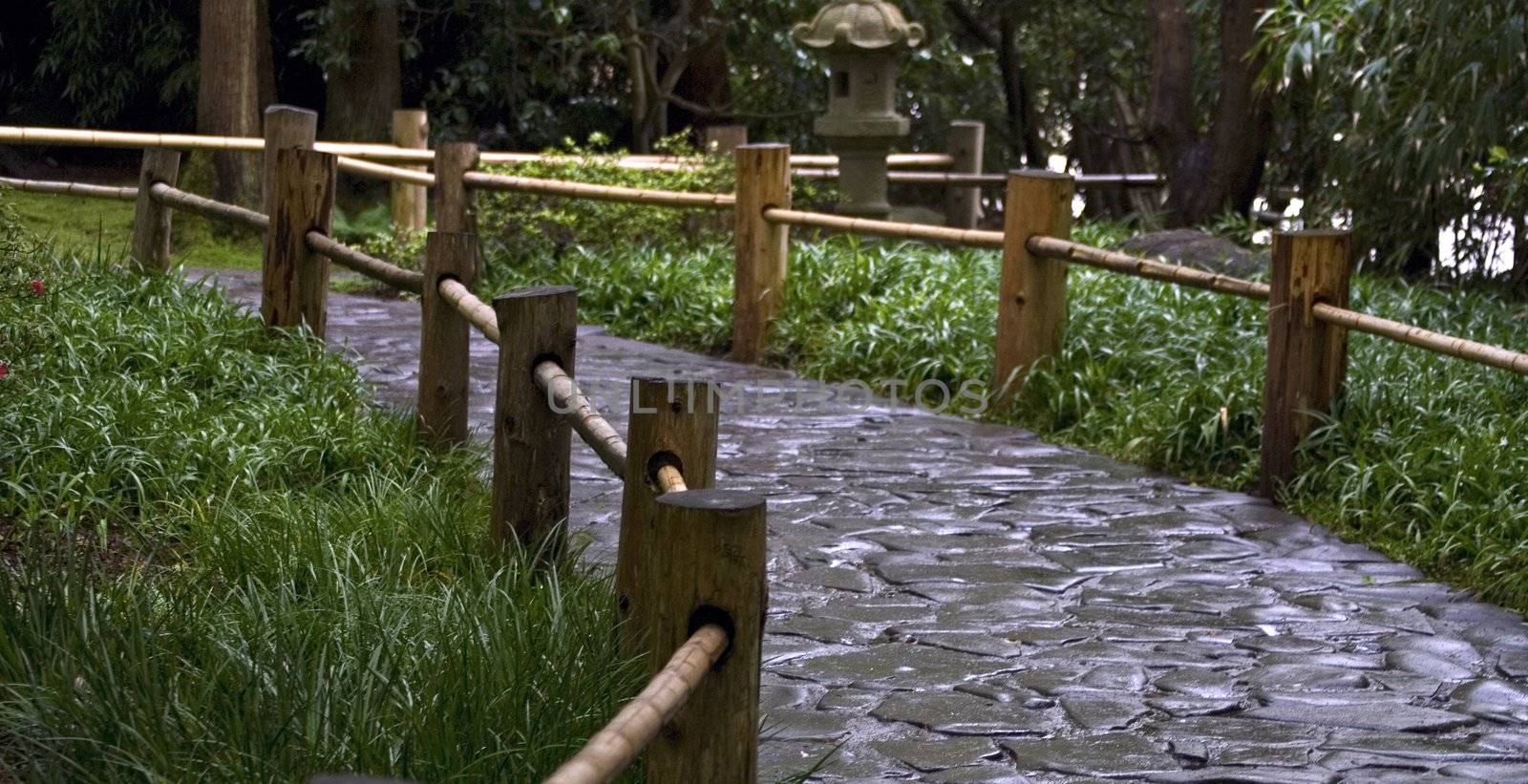 Stoned road with the wooden fence in a japanese garden