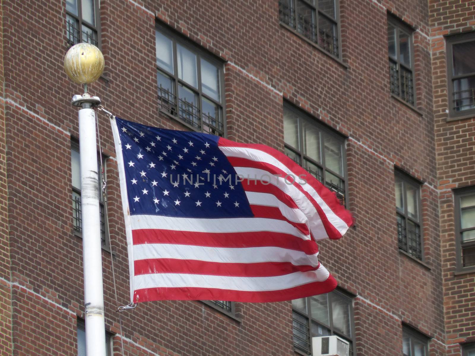 american flag in the breeze in front of a condominium