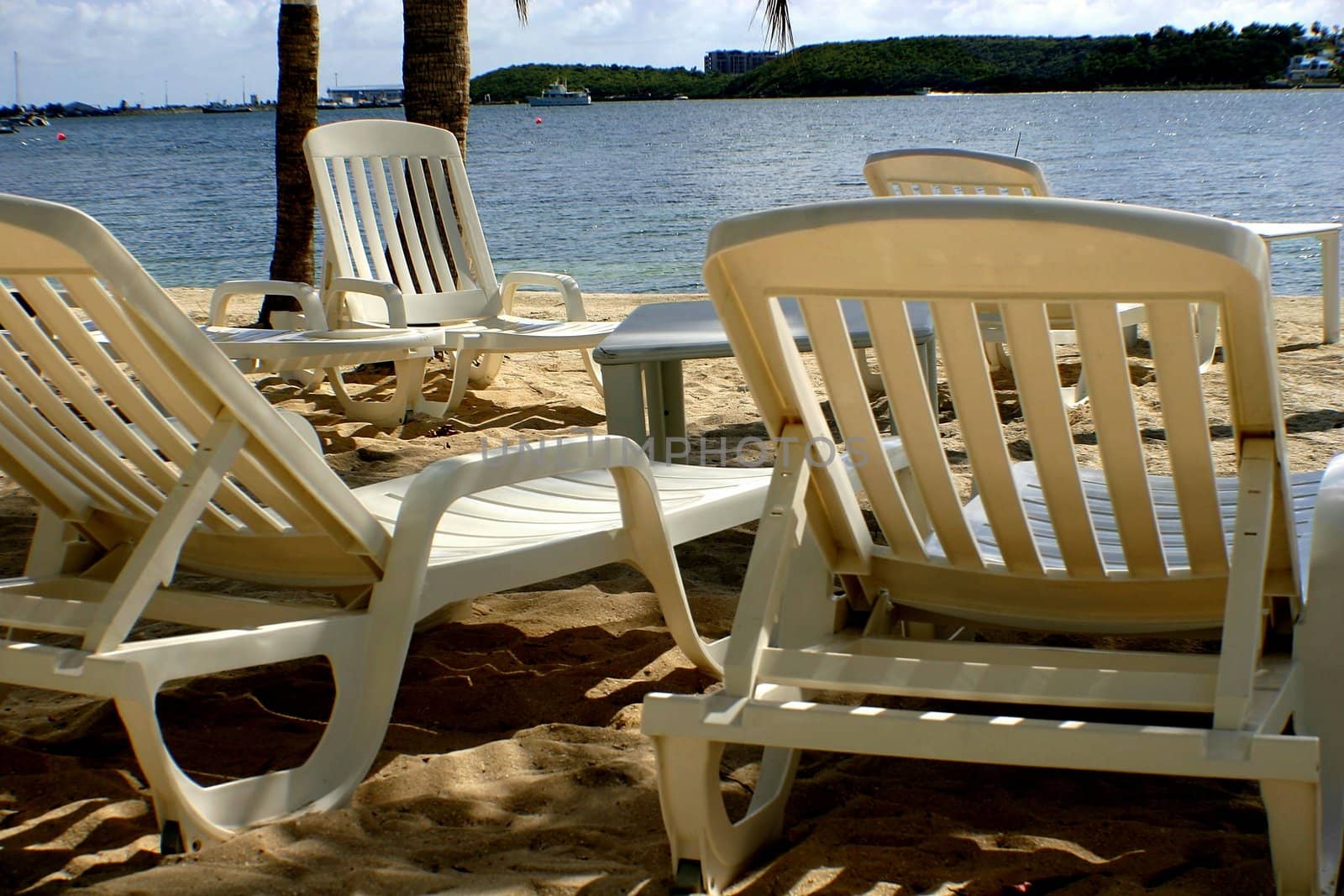 Beach lounge chairs under tropical sun