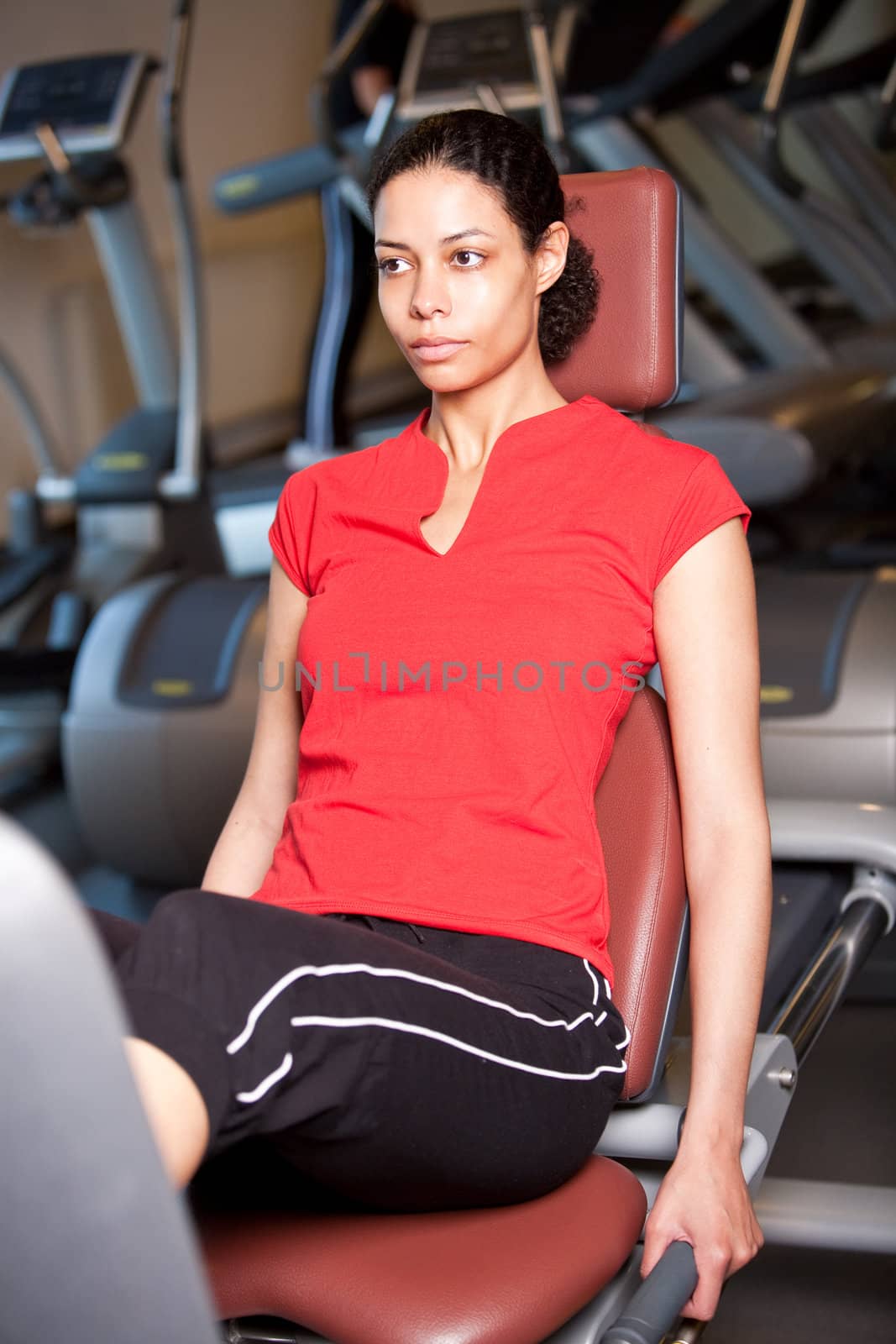 Beautiful girl at the machines in the gym working out