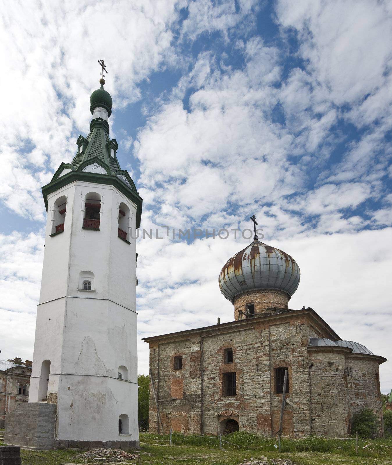 Church ruins and white belltower in renovating monastery