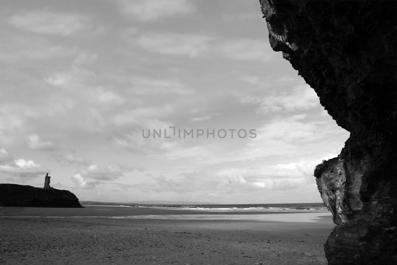 cliffs on the beach in ballybunion ireland with castle in background