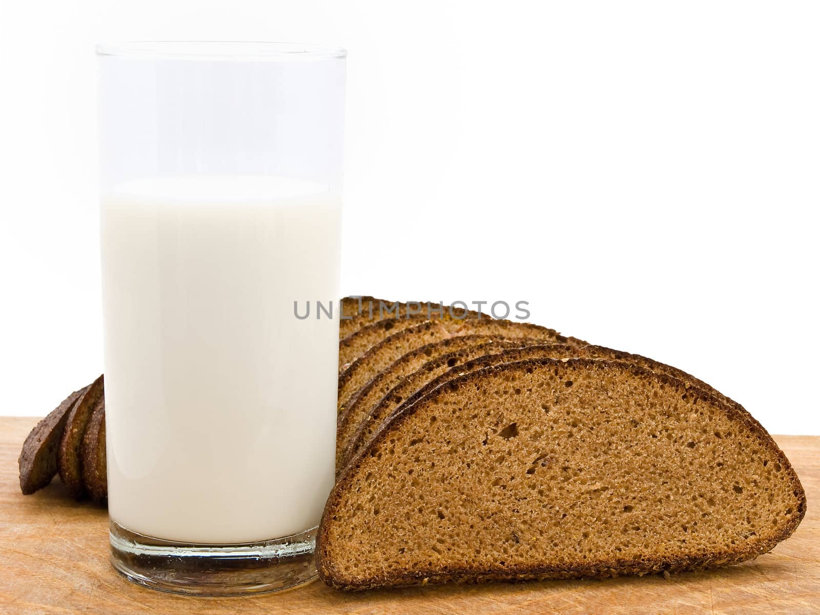 Photo of the bread and milk at wooden broad against the white background  
