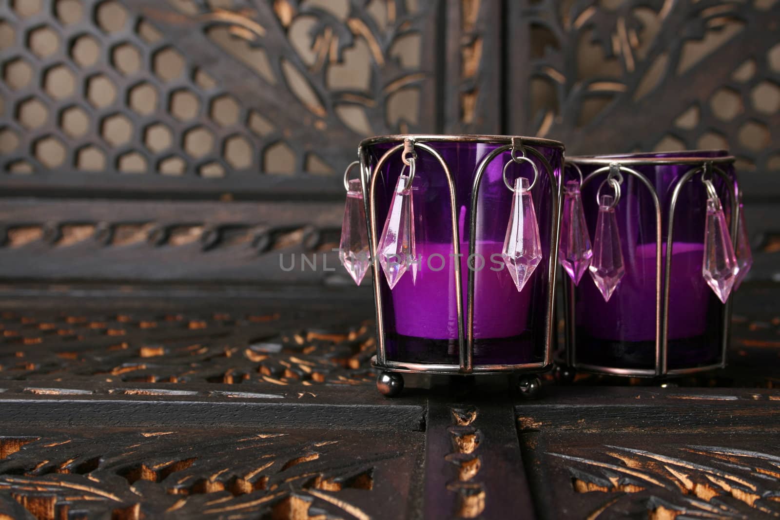 Two purple crystal candle holders on a rustic background