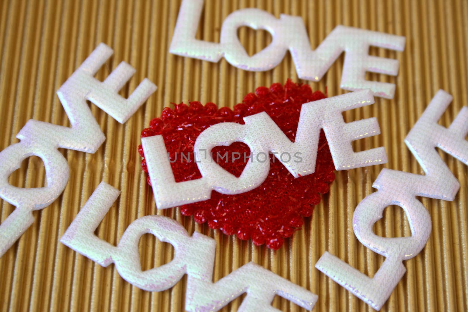 The word love on a golden background on a red heart