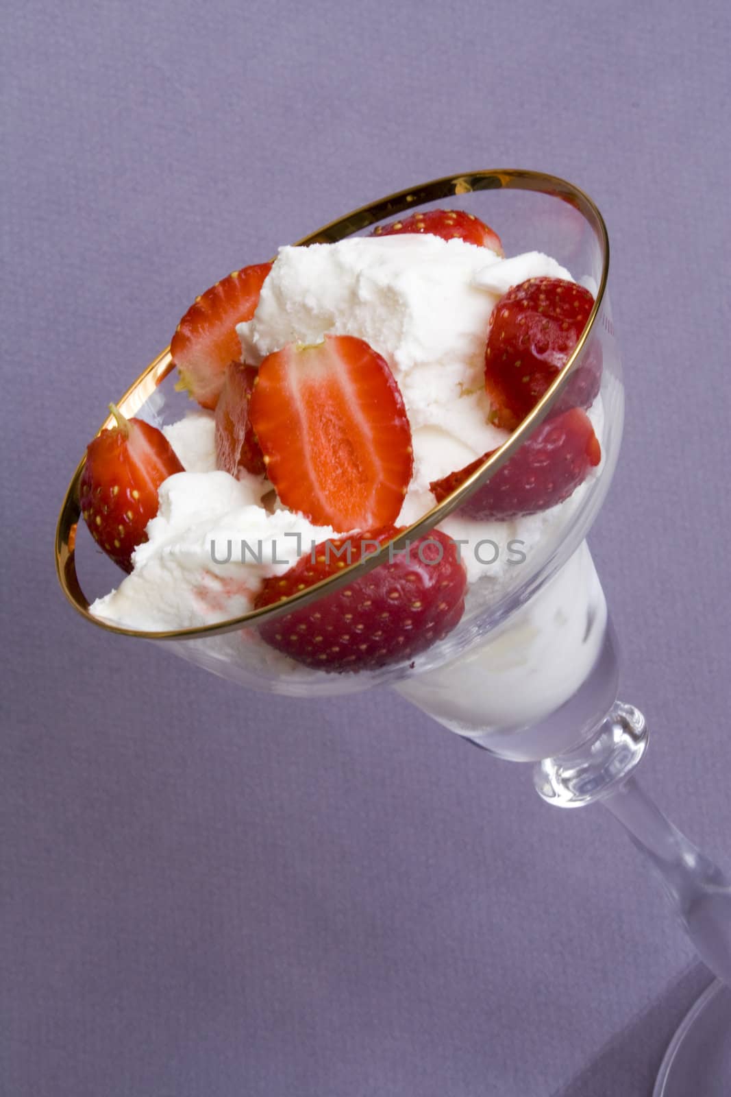 White tasty ice-cream in glass with cut strawberry