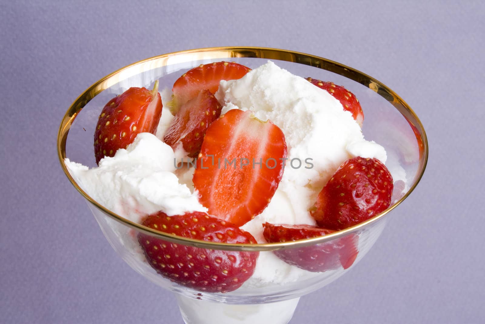 White tasty ice-cream in glass with cut strawberry