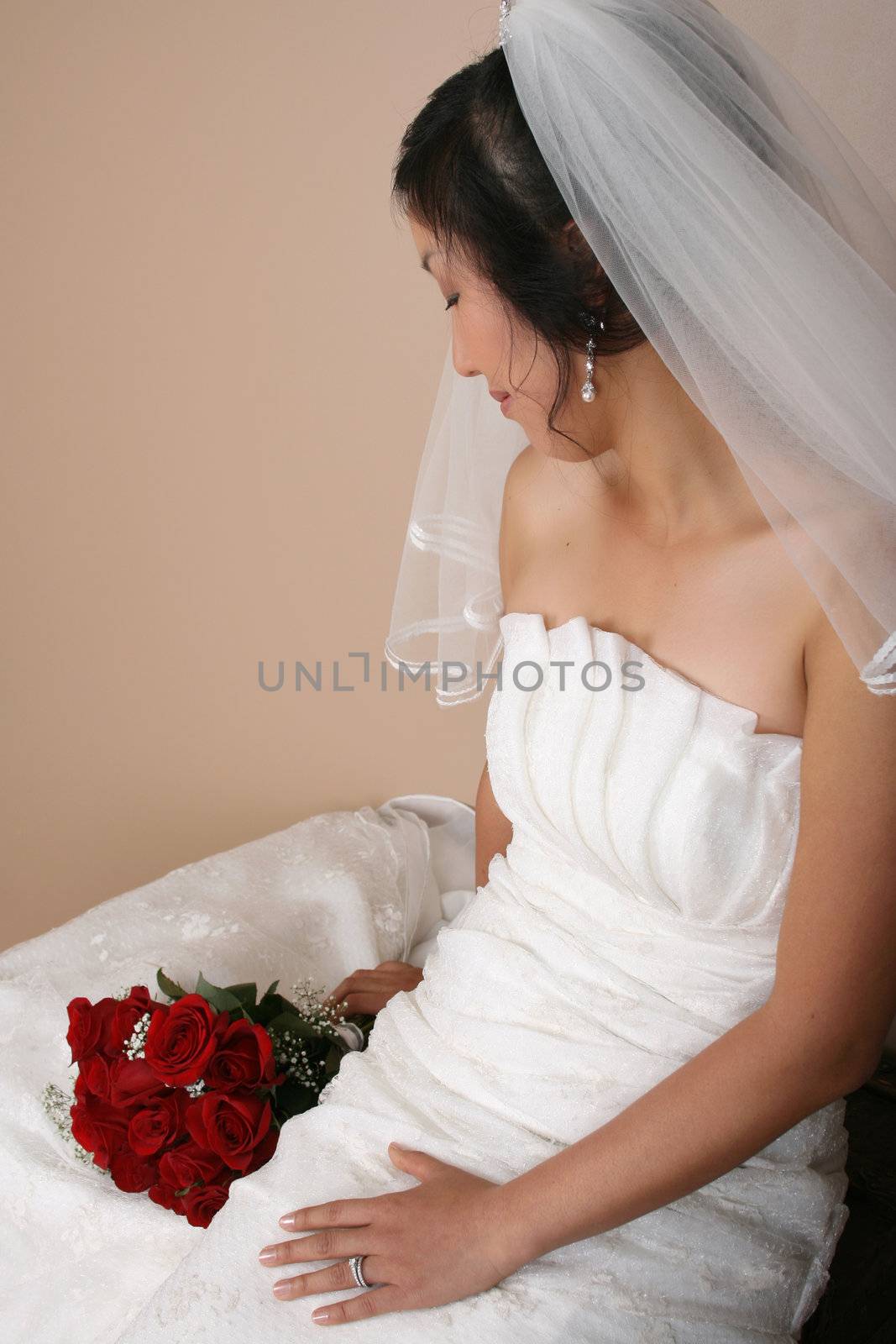Beautiful bride wearing a traditional gown with red roses