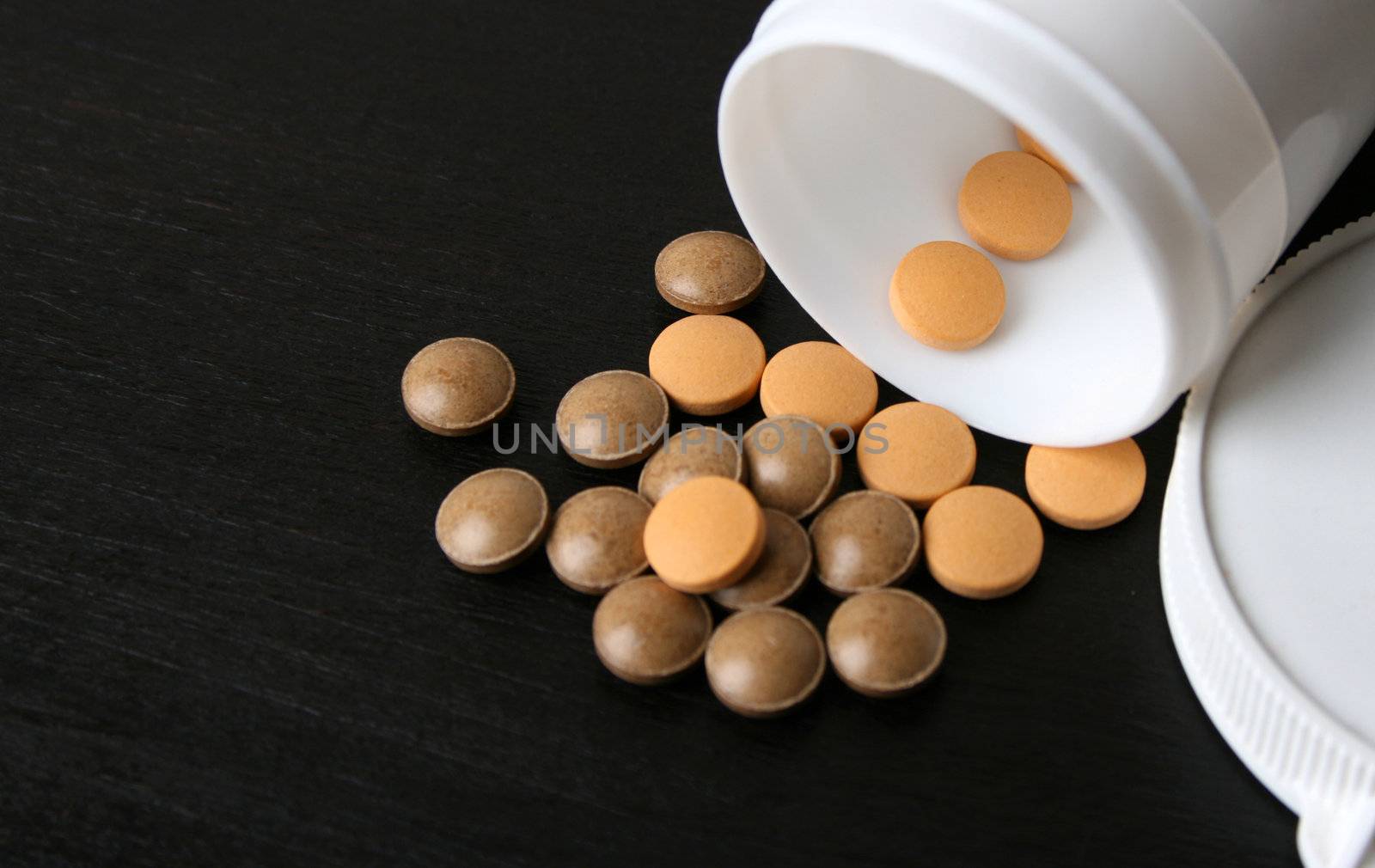 Pills falling from a bottle. FOCUS on pills in bottle