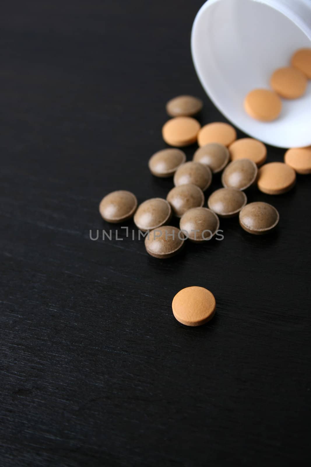 Pills falling from a bottle. FOCUS on pills in bottle