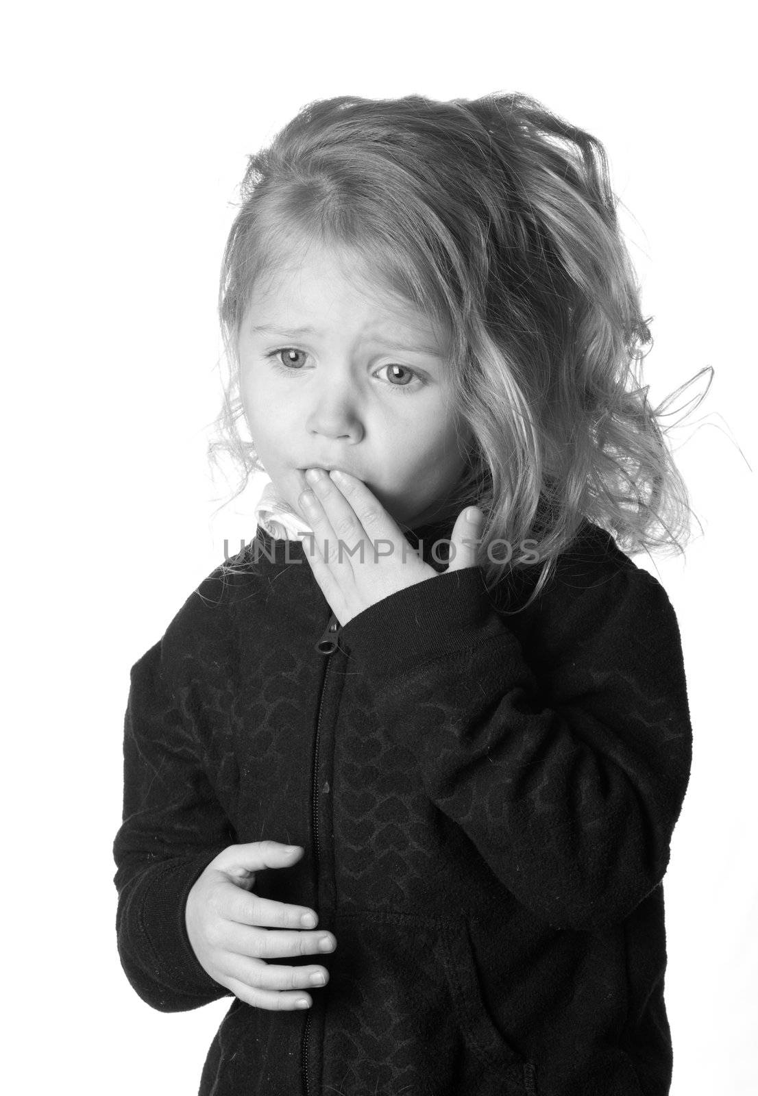A black and white photograph of  a girl who could be expressing numerous emotions.