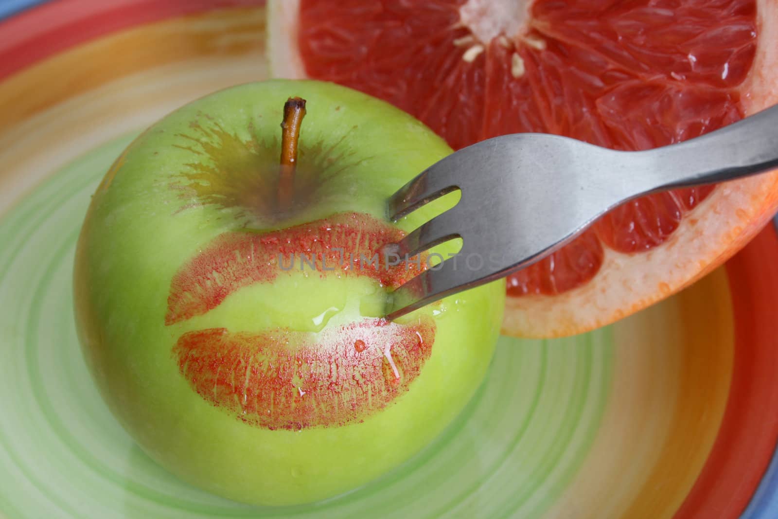 Sliced Pomelo and a whole apple with red lips