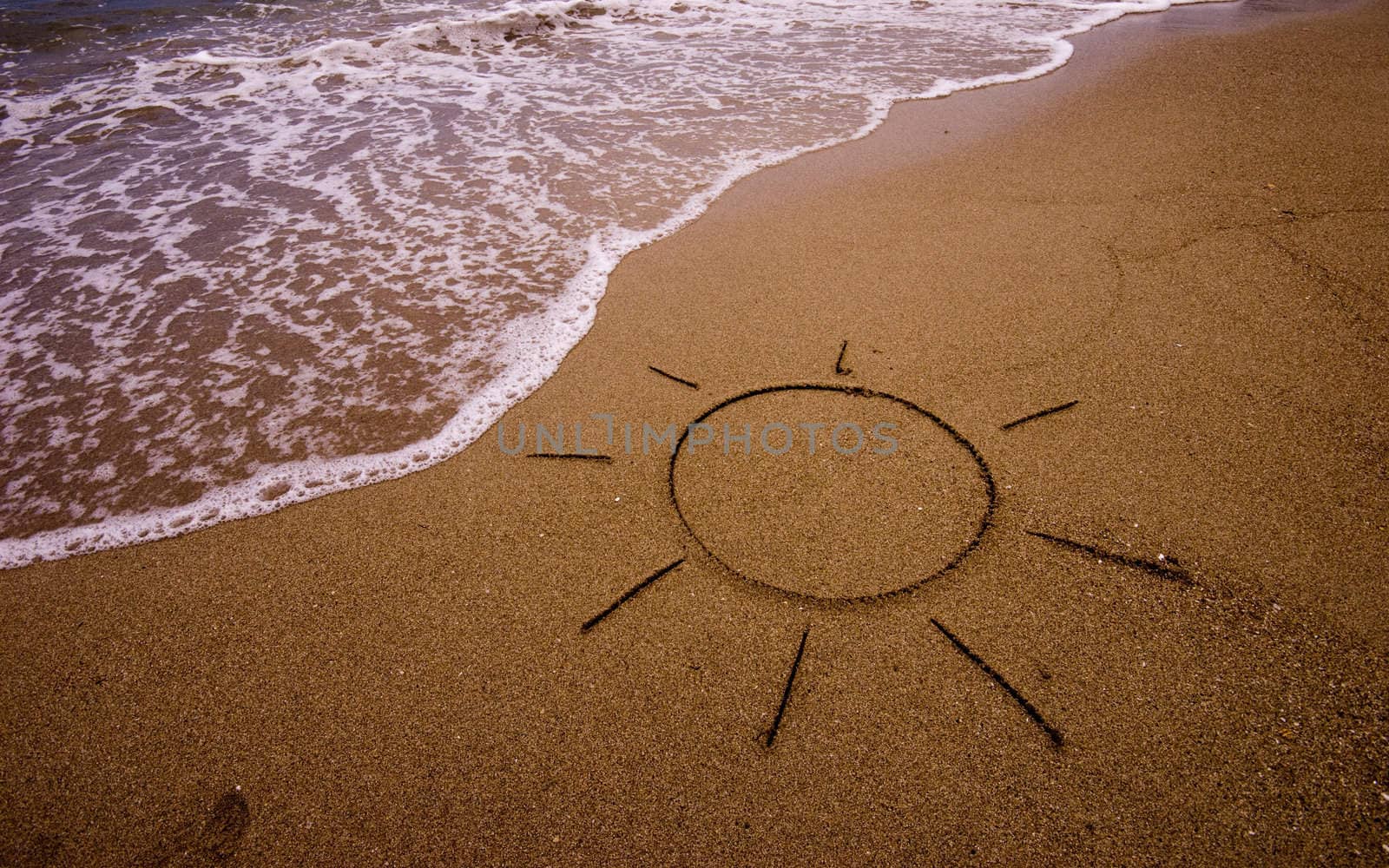 Sun drawn in sand on beach