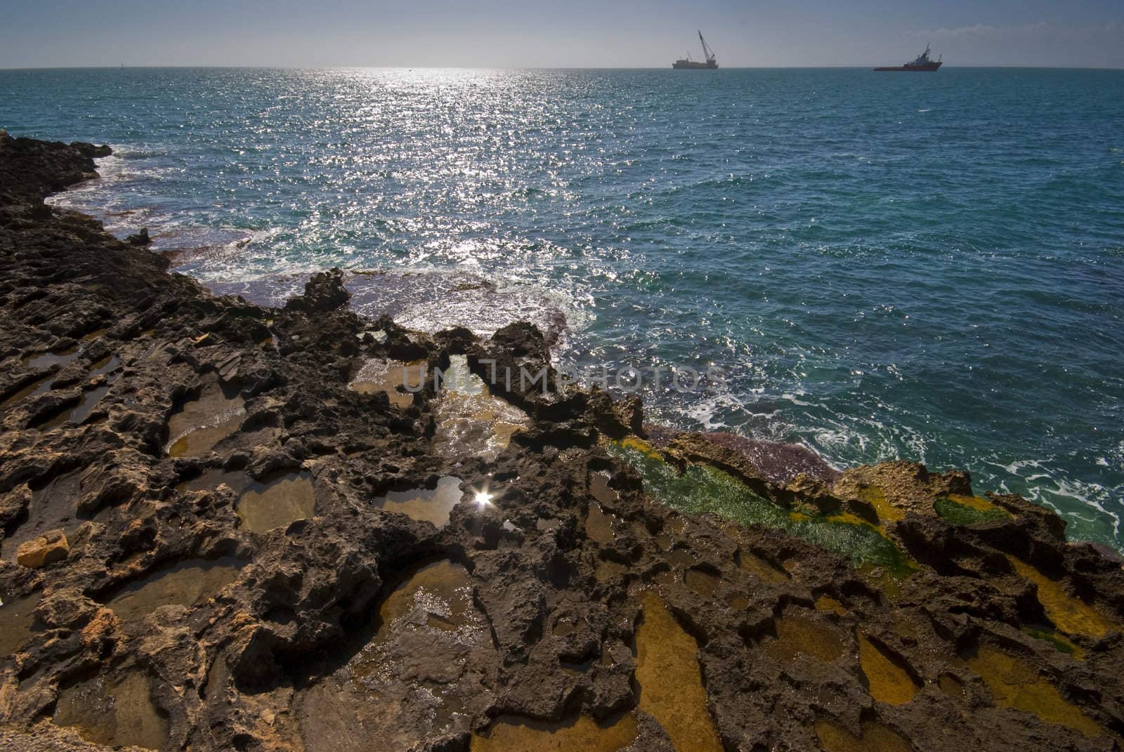 Seashore with ships on horizon