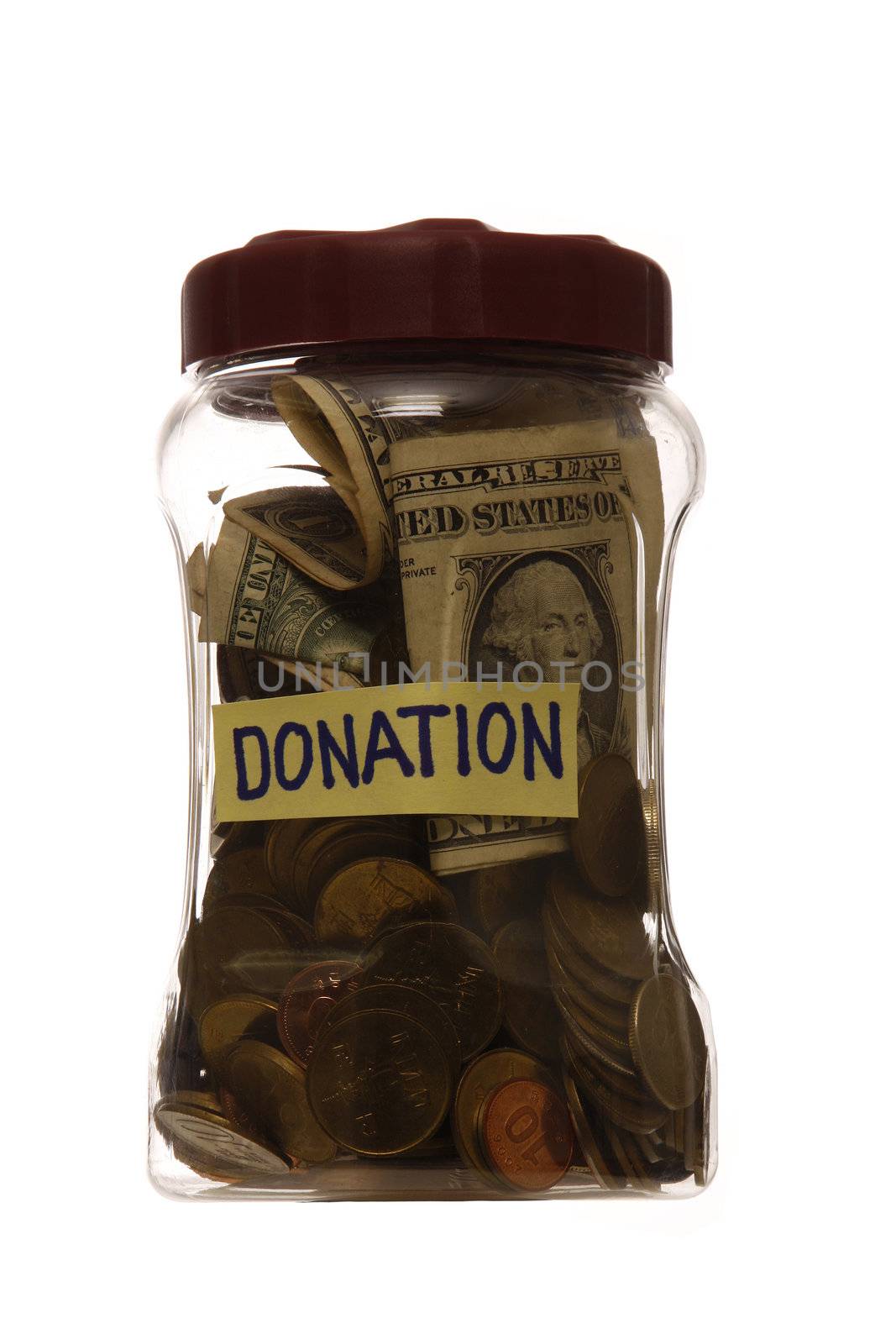 Donation with coins and dollar note in a jar, isolated in white background.