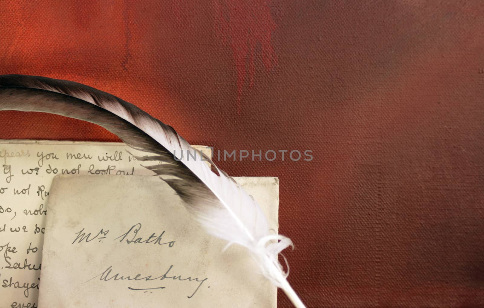 Period set up of a letter,quill pen set on top of a wooden mantle against a red grunge background. All props recreated by self as artist.