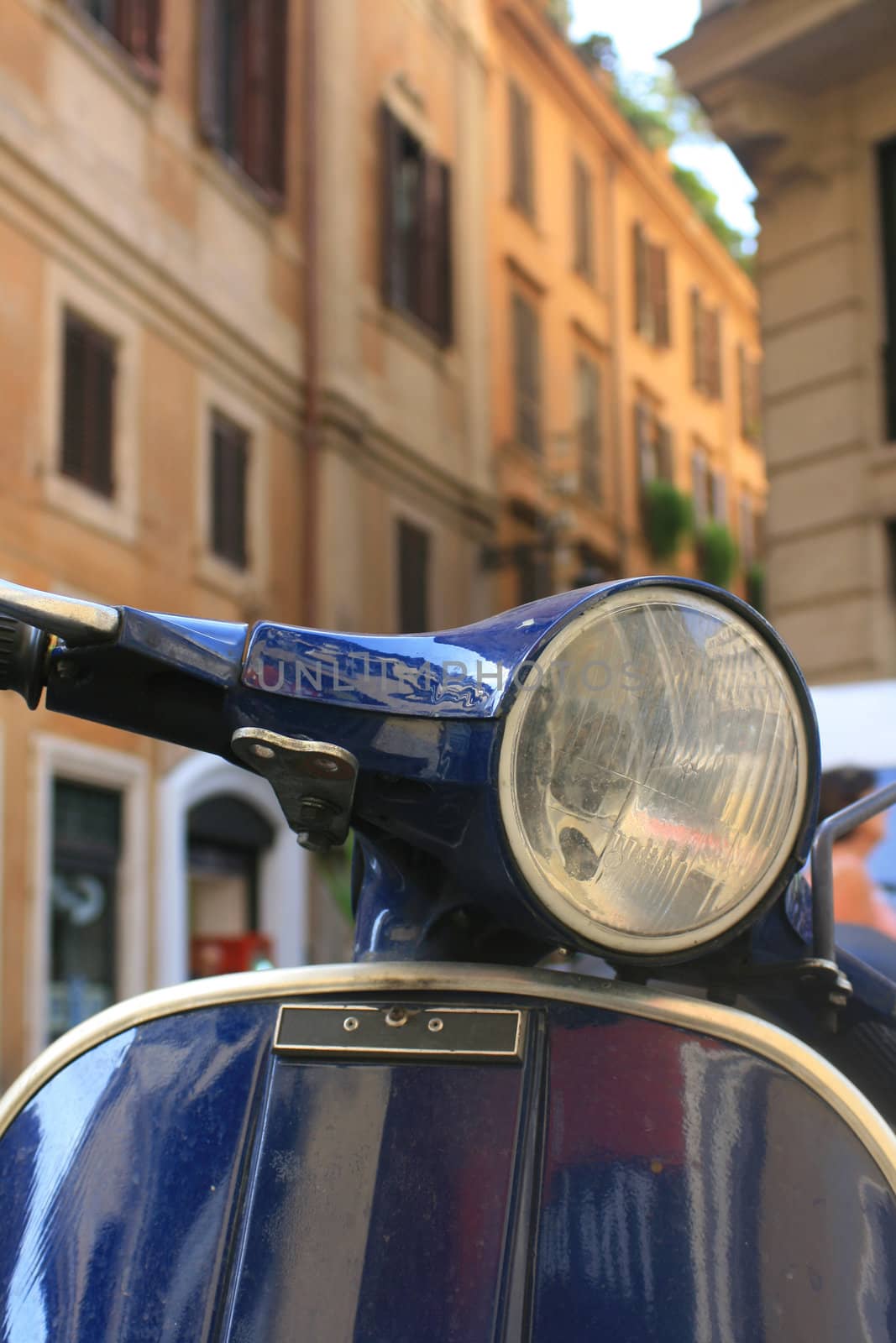 Italian motorbike/scooter in Rome,Italy with buildings to background.