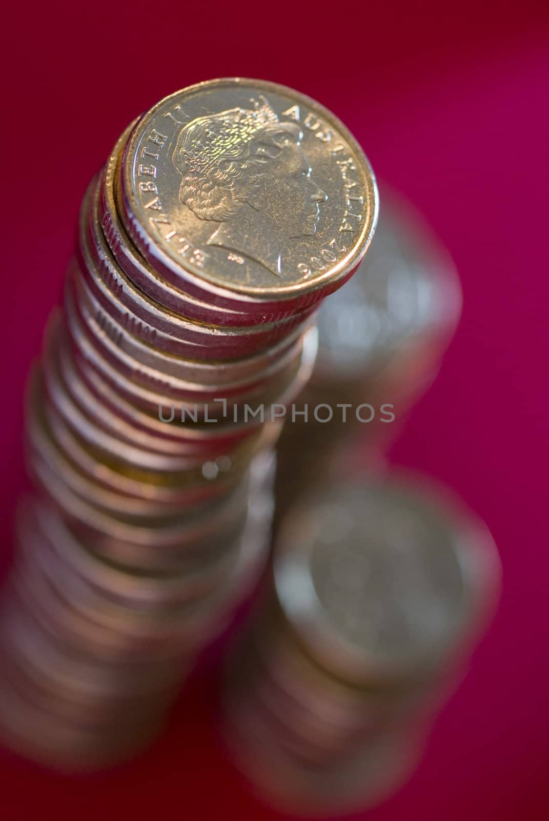 a large stack of australian dollar coins on a red background