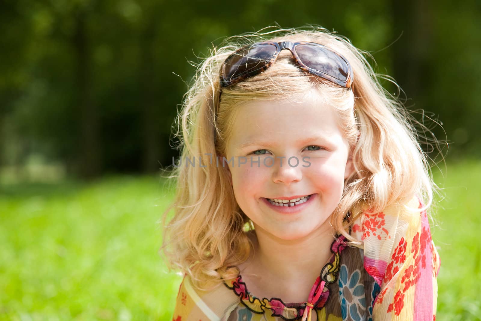 Cute young girl of 5 years old with her mothers sunglasses