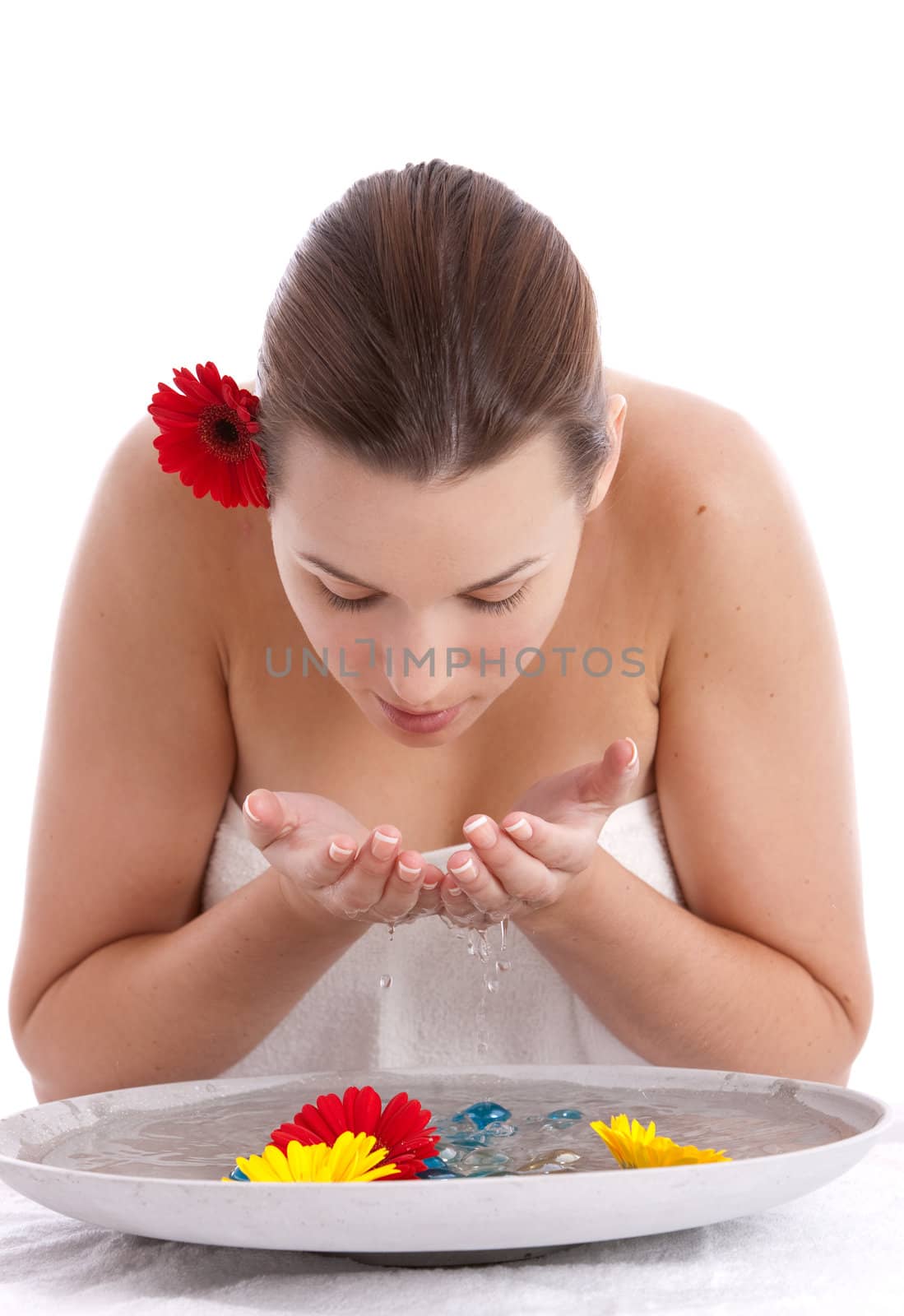 Beautiful young woman washing her face with fresh water