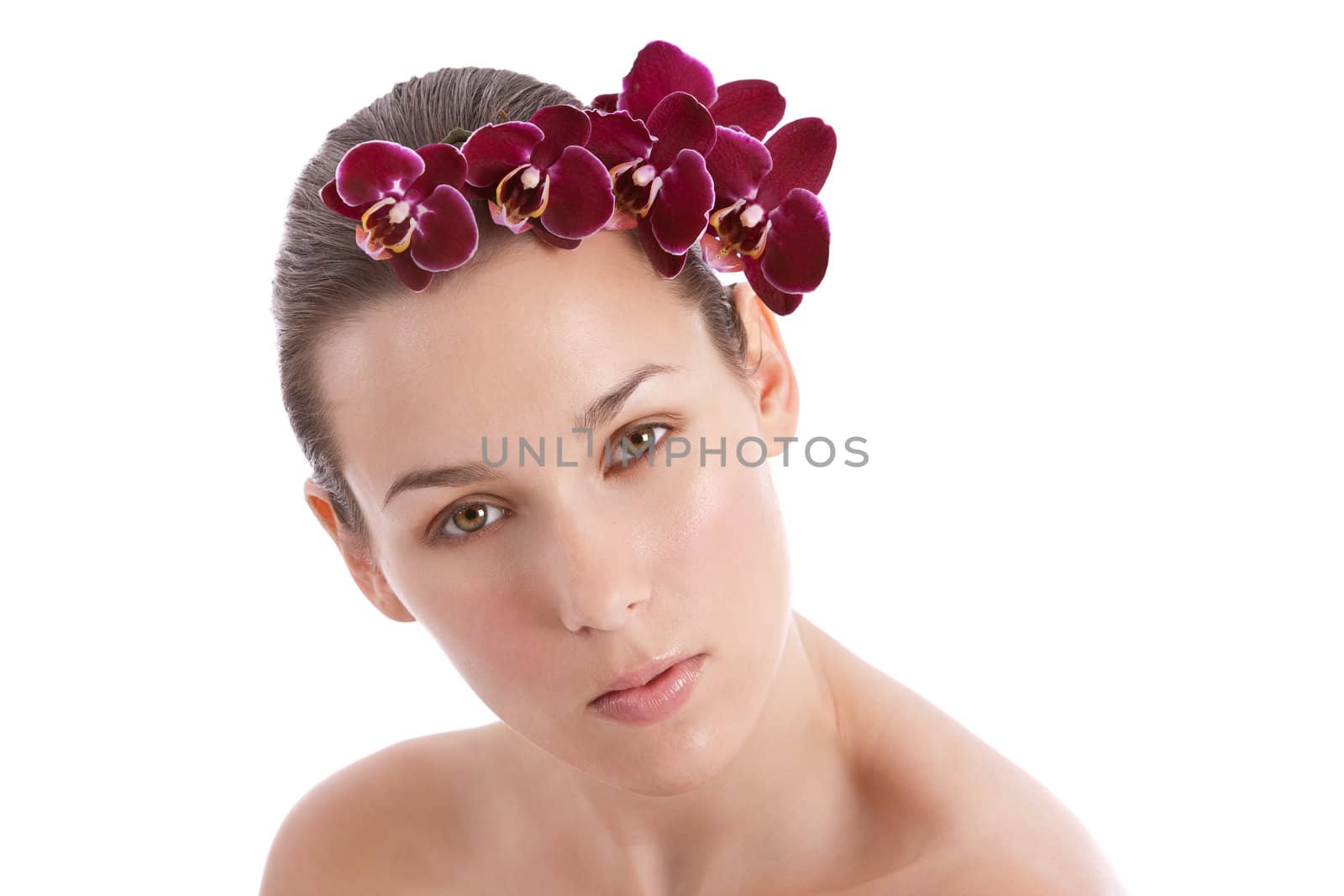 Beautiful young woman with fresh purple orchids in her hair