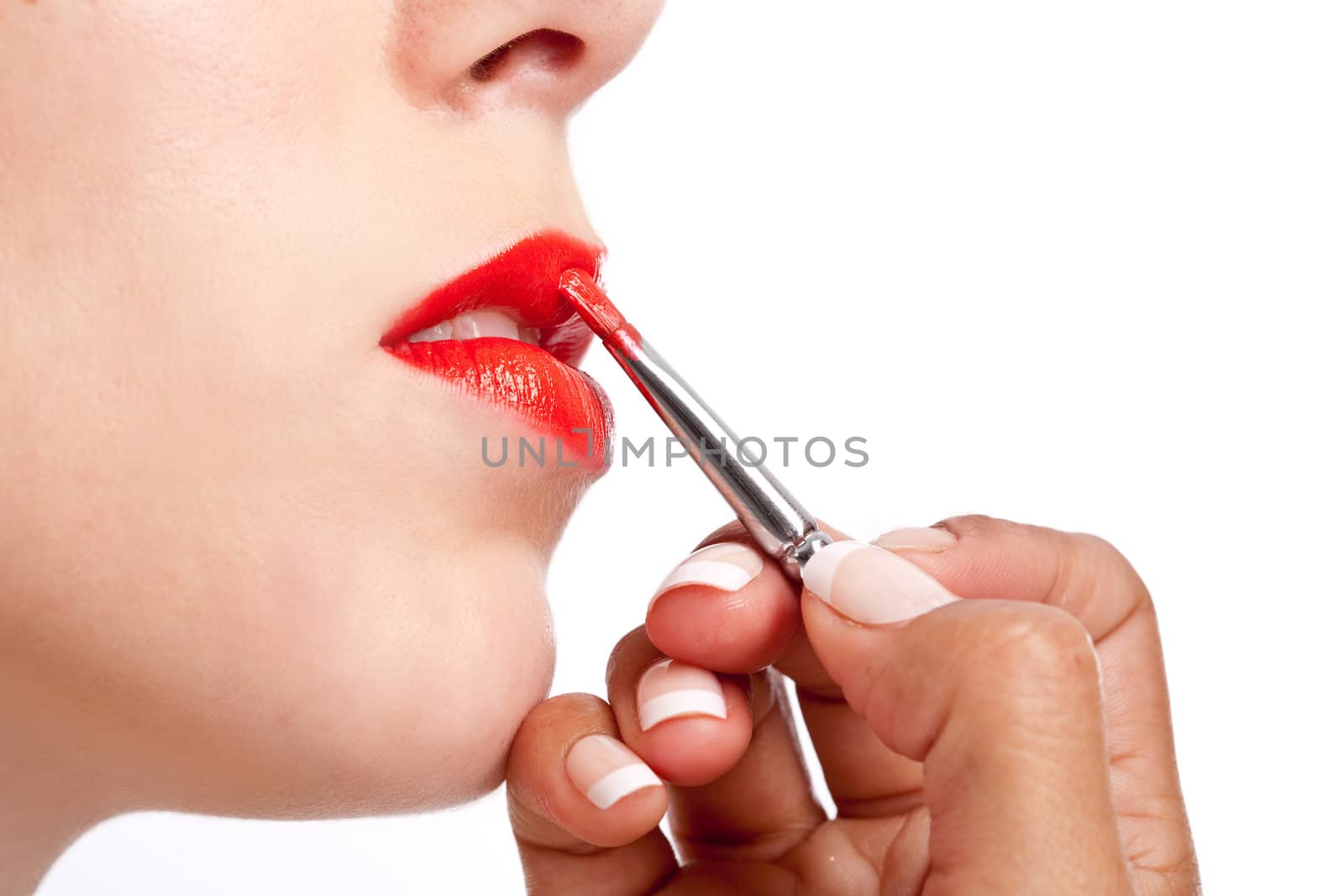 Beautiful woman getting her lips made up by a makeup person