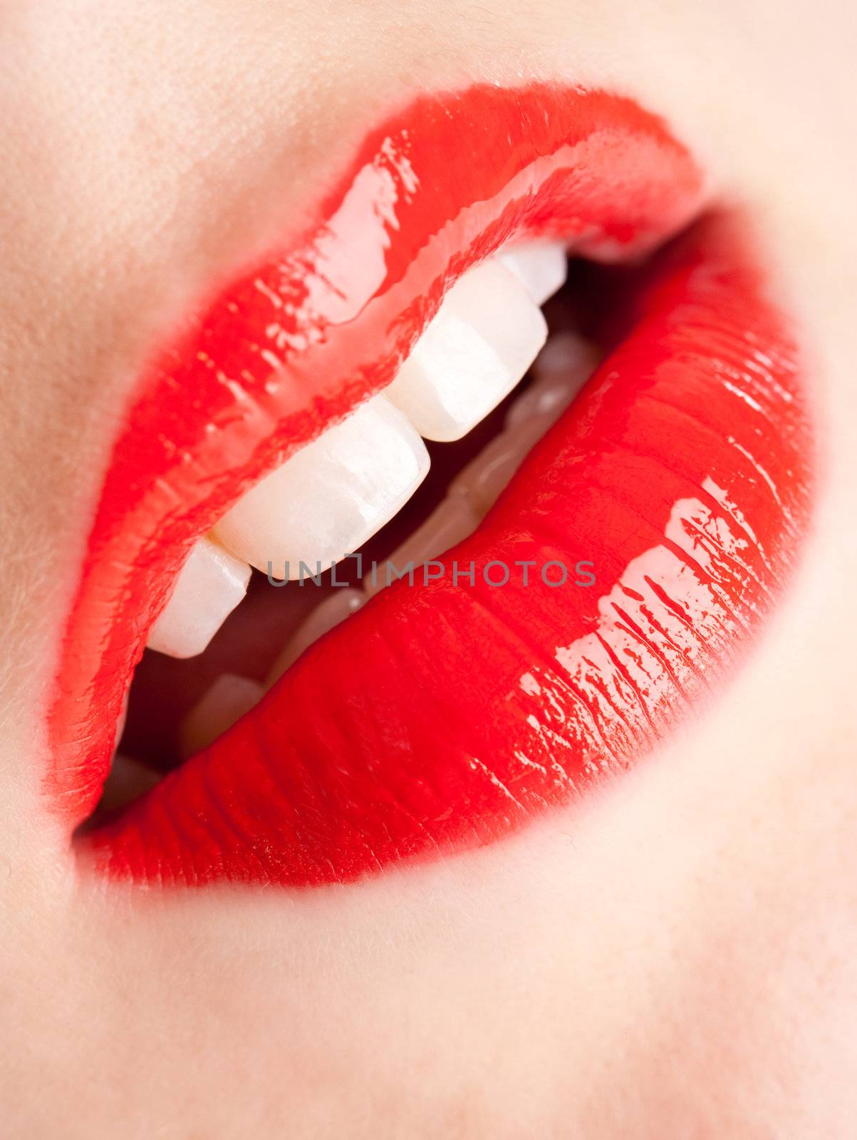 Female mouth with bright shiny red lipstick