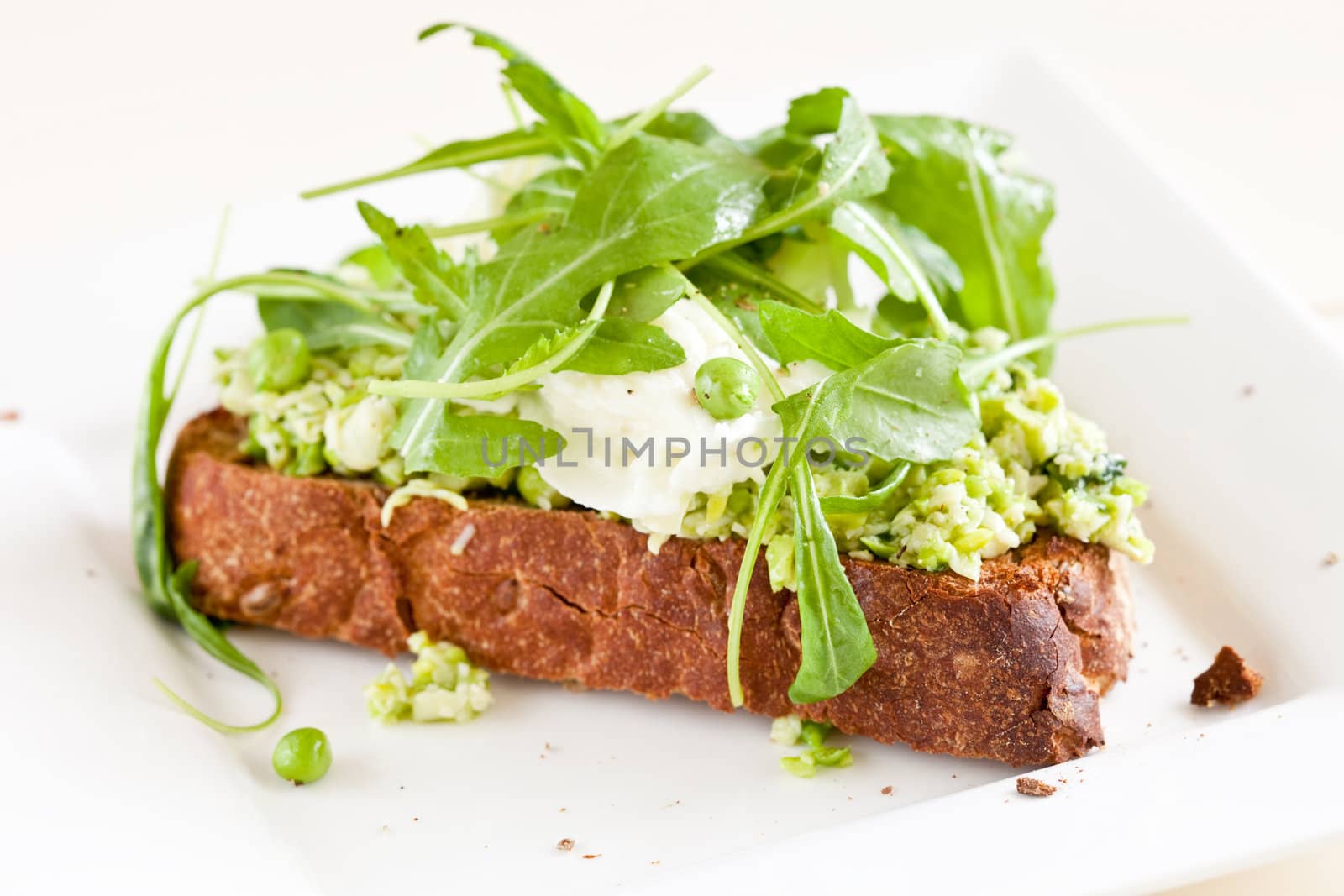 Crostini with a puree of peas and broadbeans topped with mozarella and wild rocket