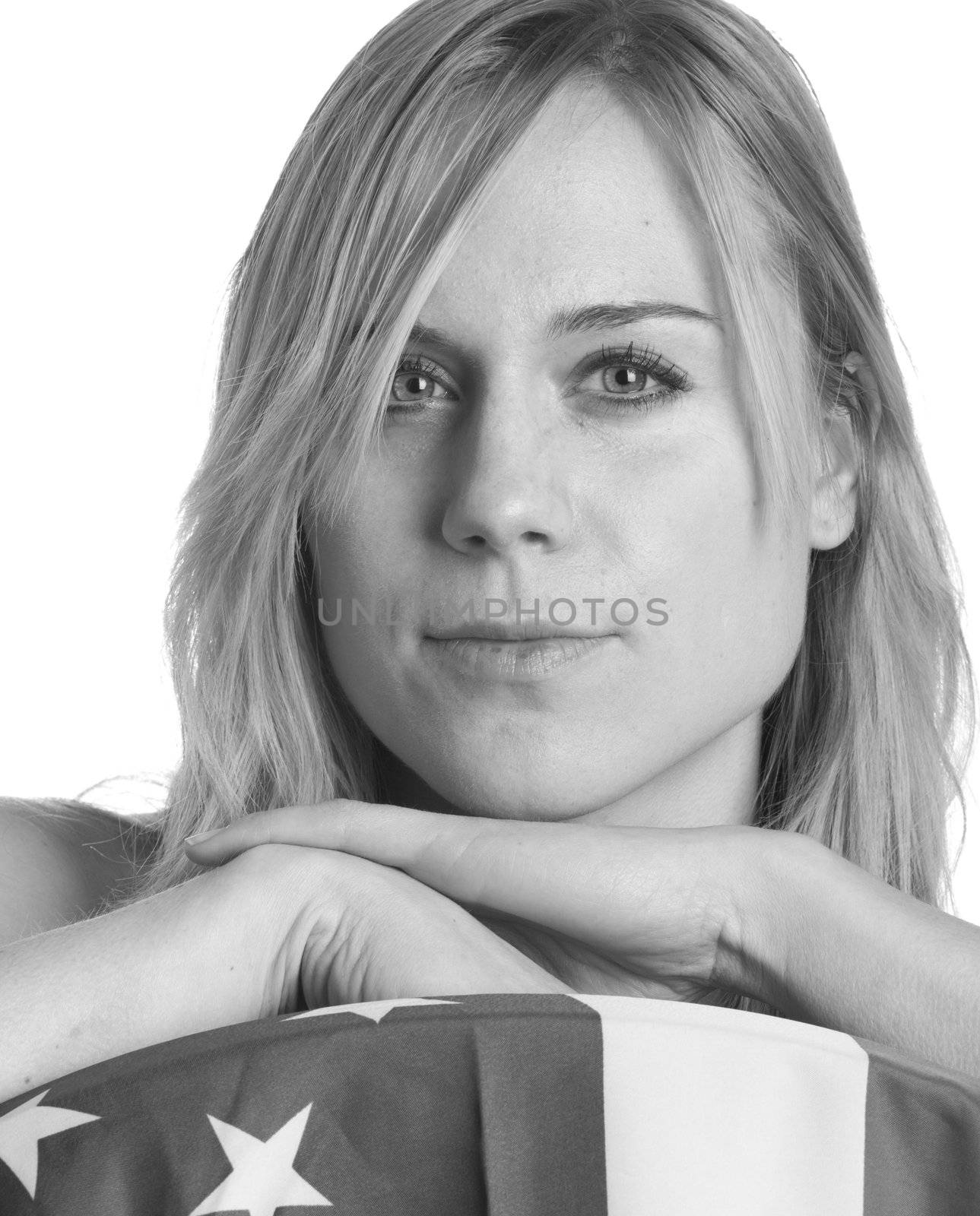 A black and white photo of a girl resting on a flag.