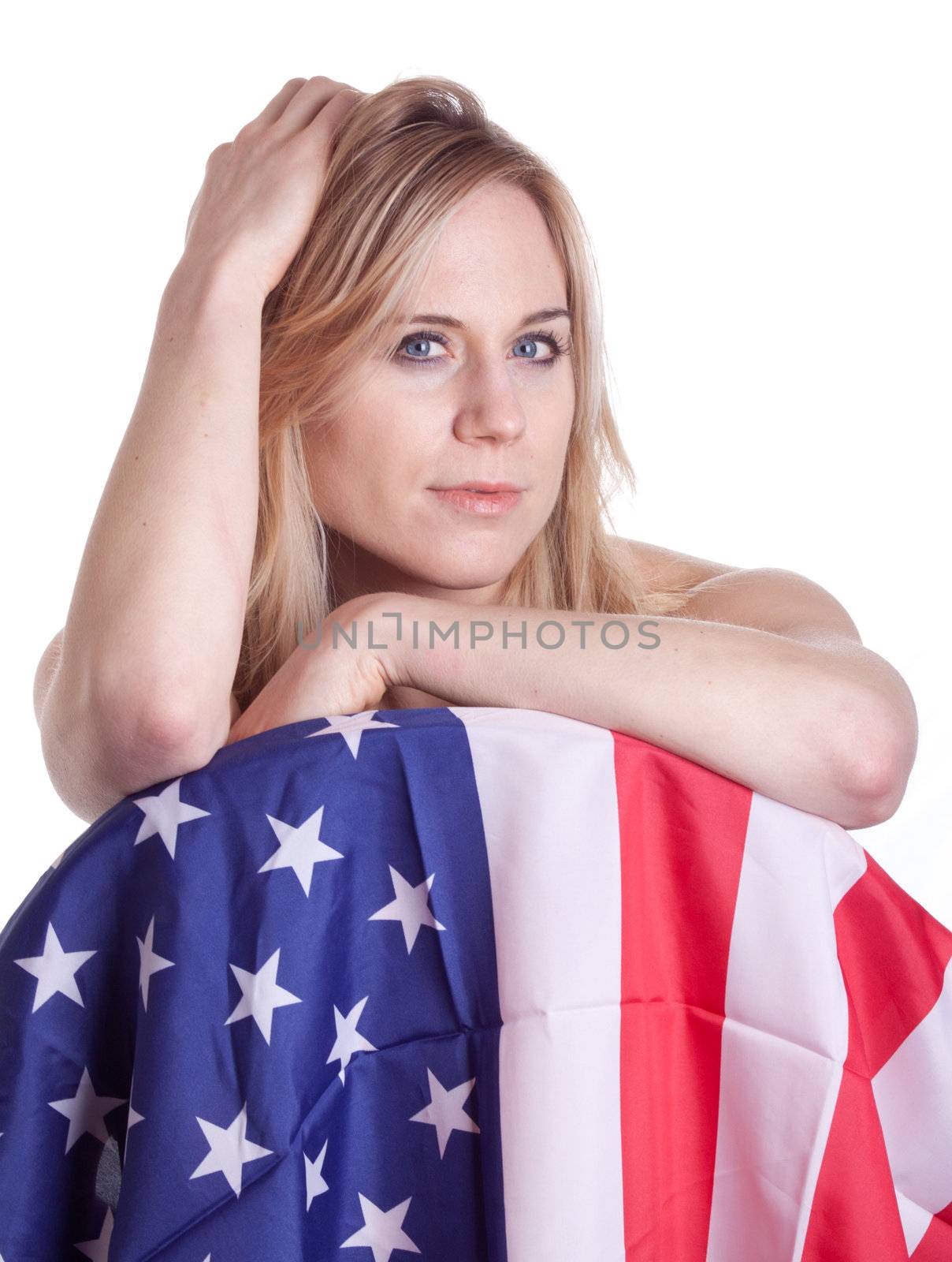 A woman looks slyly to the camera.  Posing with an american Flag.