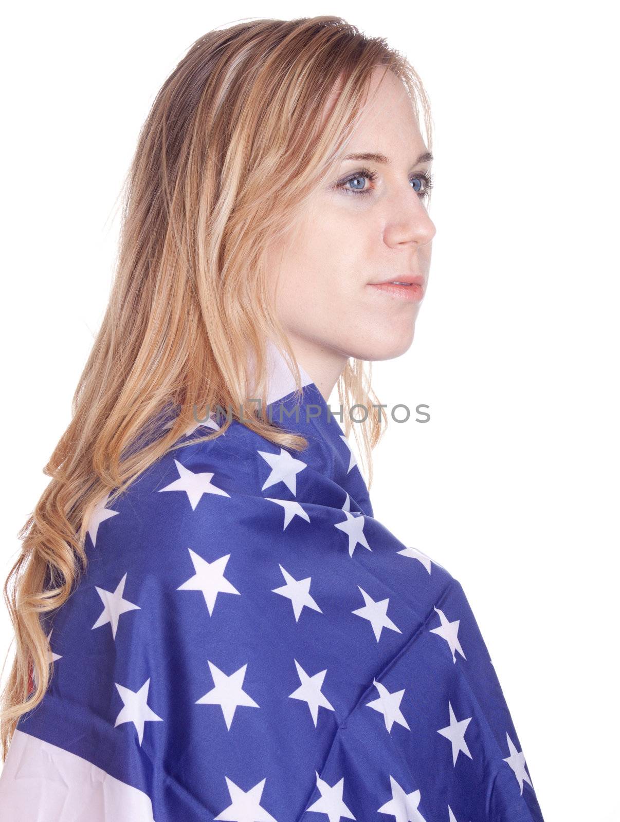 A blond girl has an American flag wrapped around her.