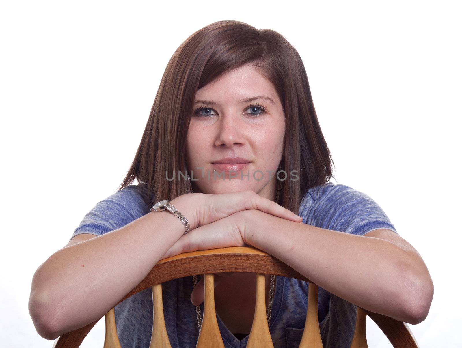 A beautiful gilr with long lashes.  Her arms are crossed over a chair.
